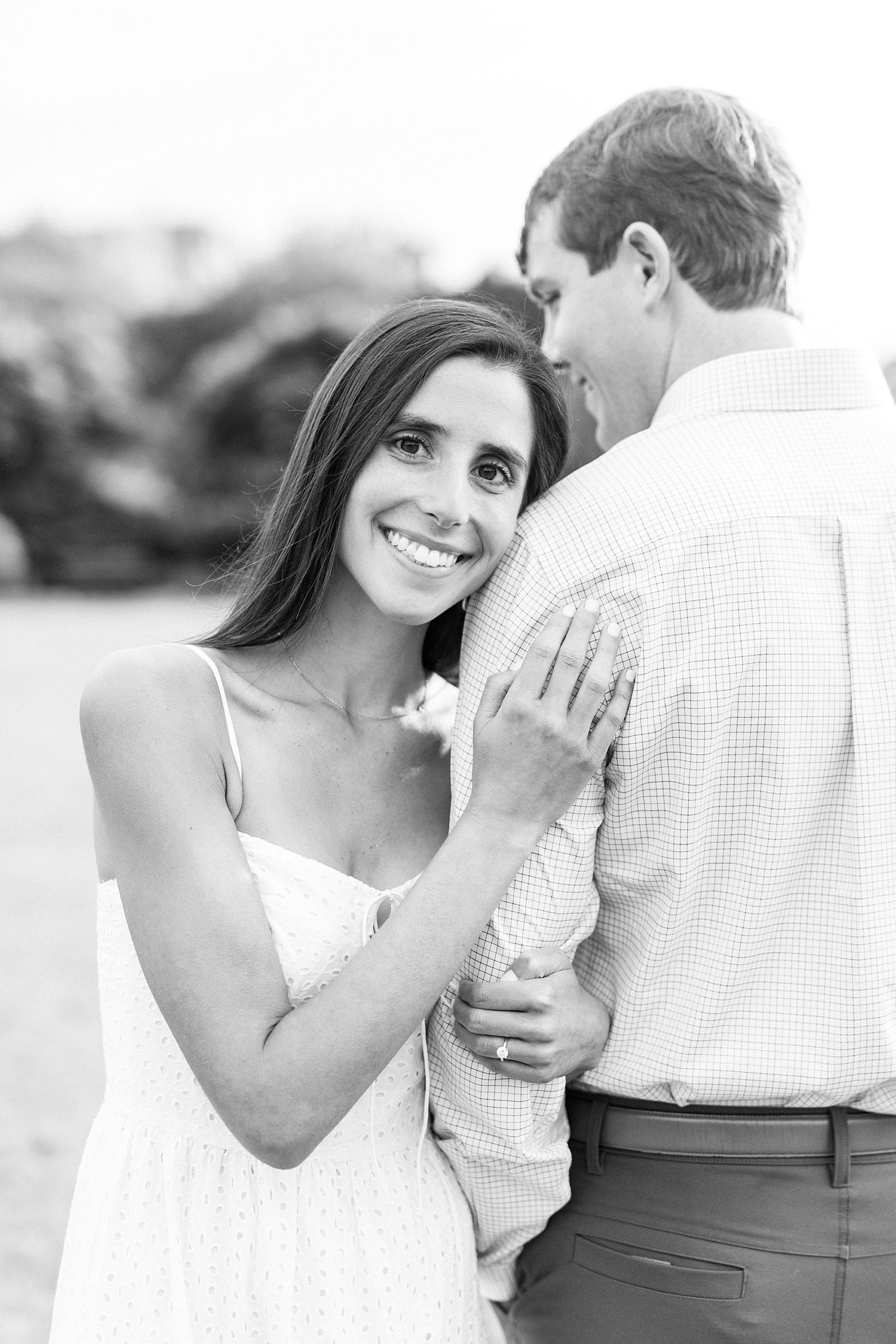 bride holds groom's arm during Midtown Park engagement session