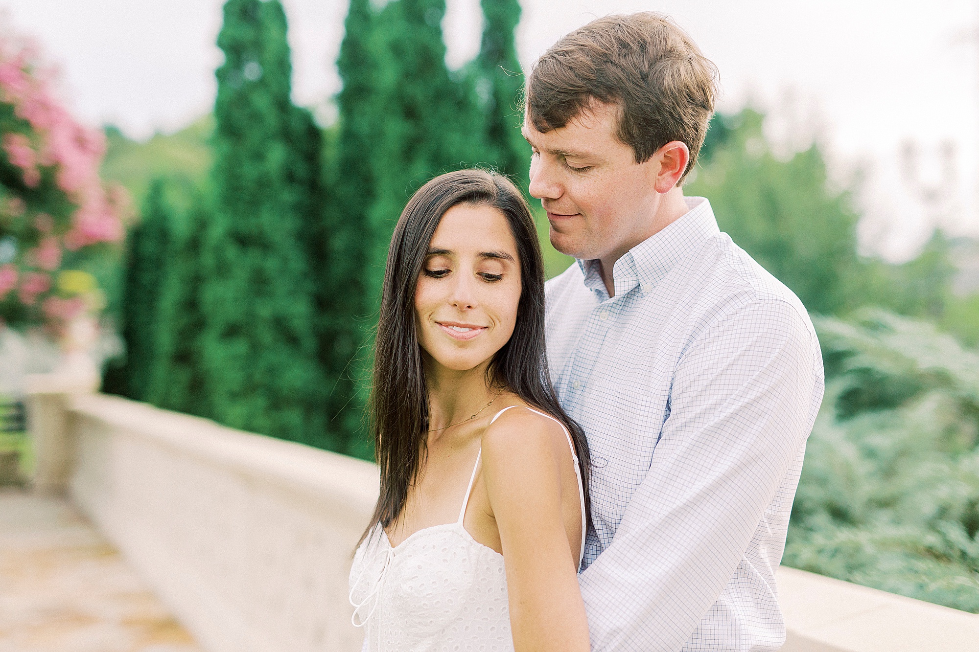 groom looks down at bride during engagement photos in the park