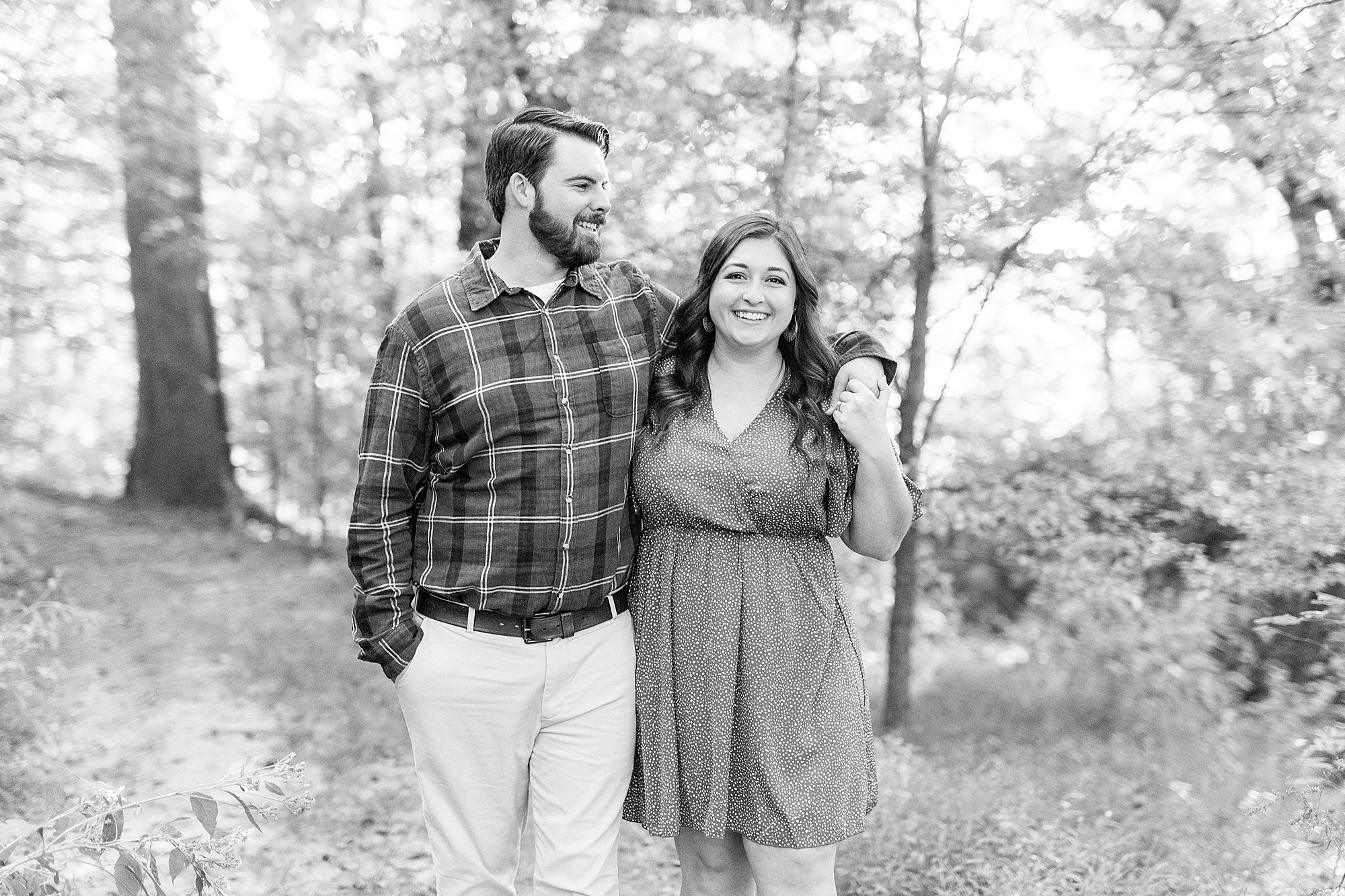 bride and groom walk through woods during fall engagement session