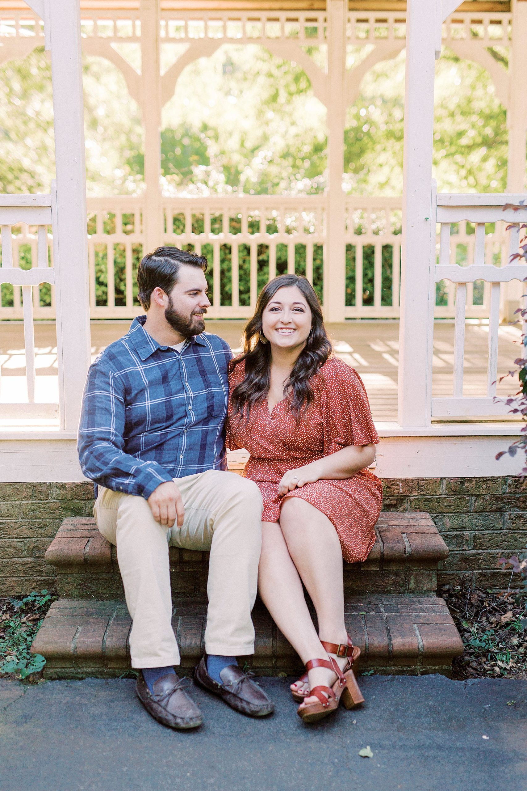 couple sits on gazebo during fall engagement photos