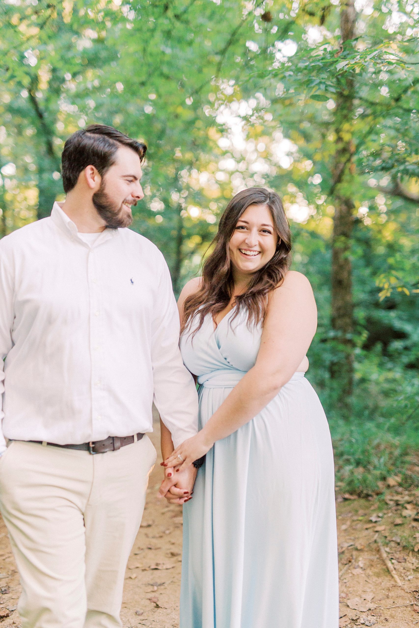 woman in light blue dress holds fiancé's arm during Sloan Park engagement session