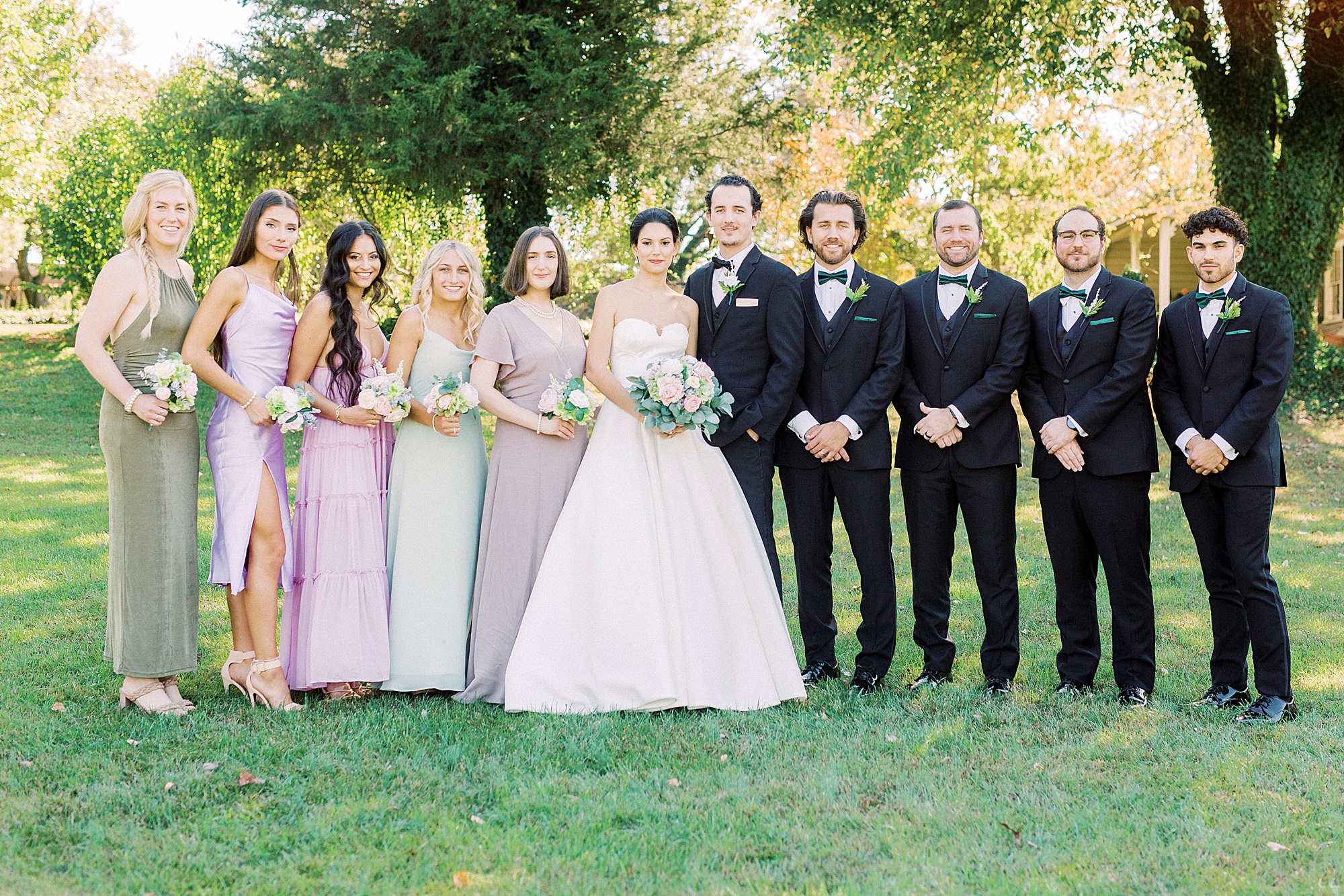 newlyweds stand with bridal party in classic tuxes
