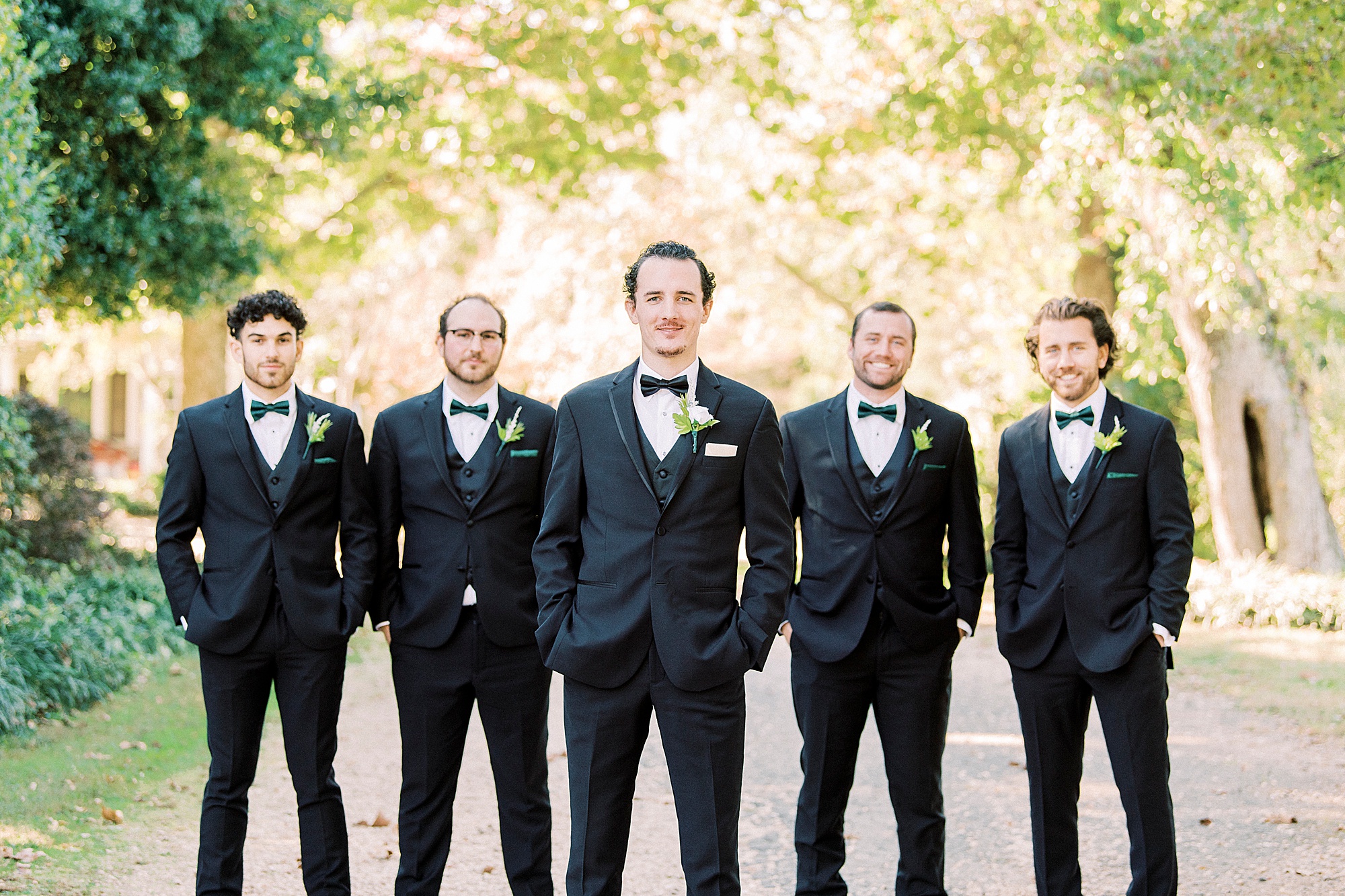 groom and groomsmen pose on drive way at the 1812 Hitching Post