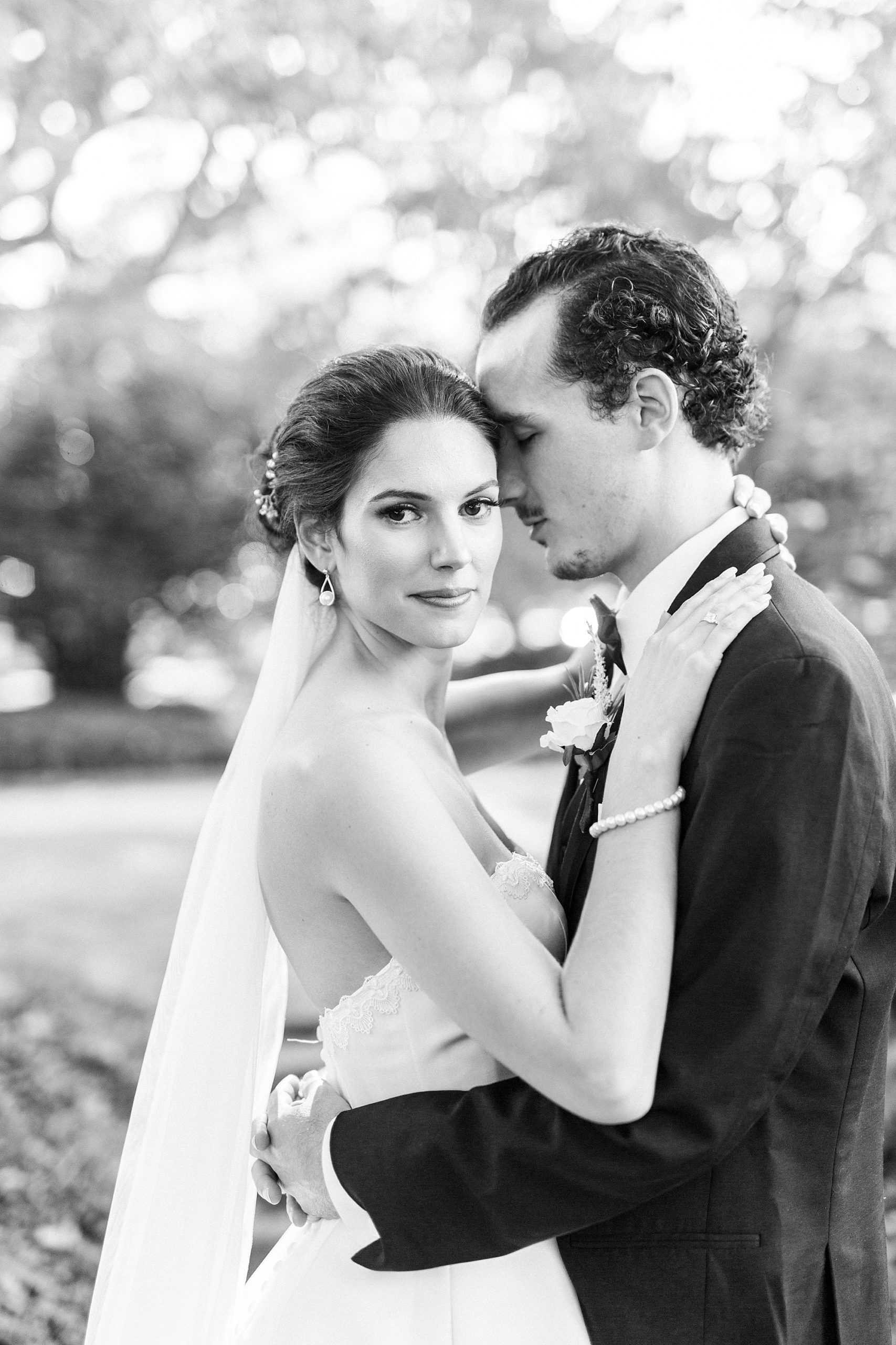 groom hugs bride to him during portraits on the lawn at the 1812 Hitching Post