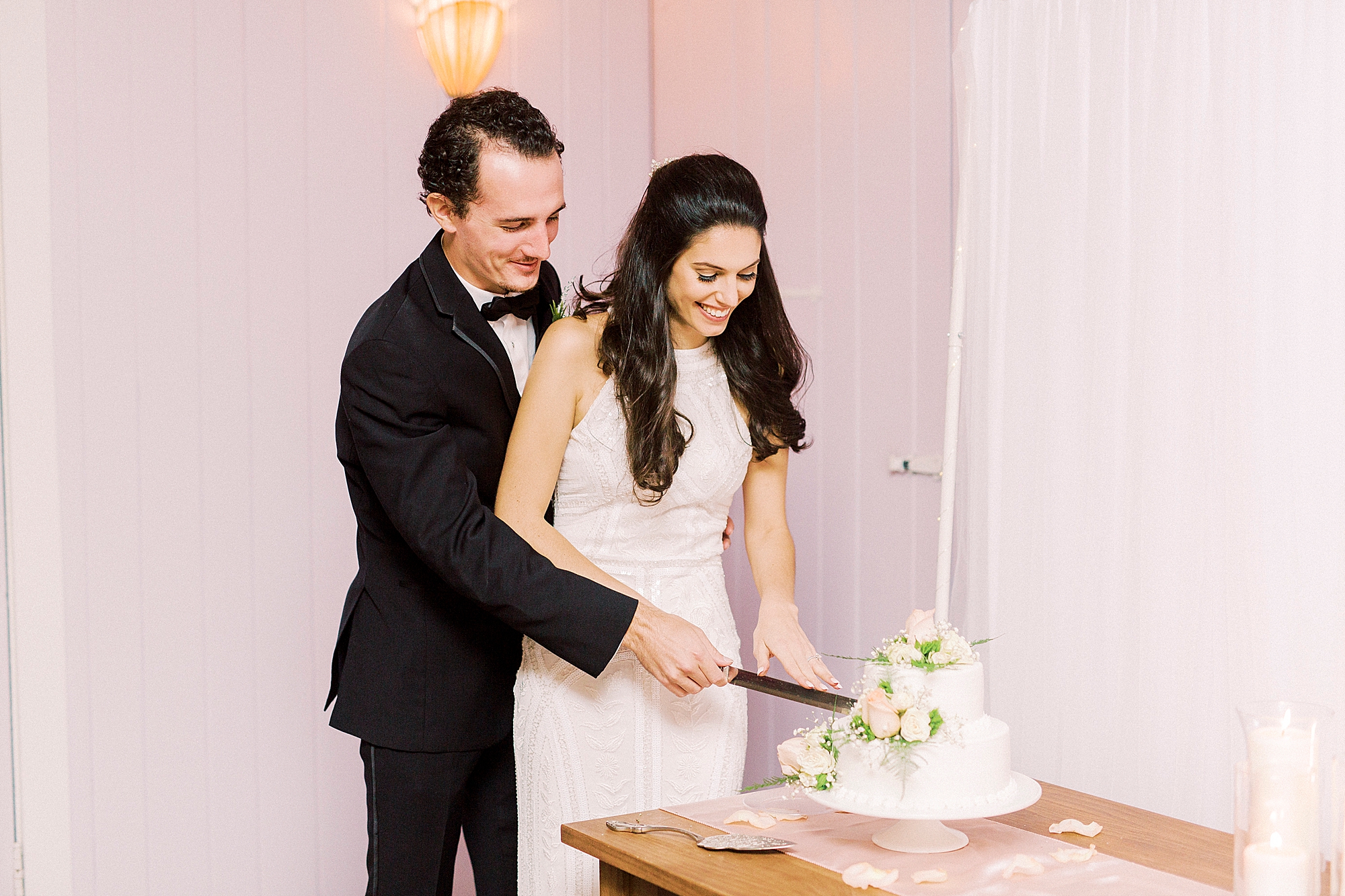 couple cuts cake during NC wedding reception