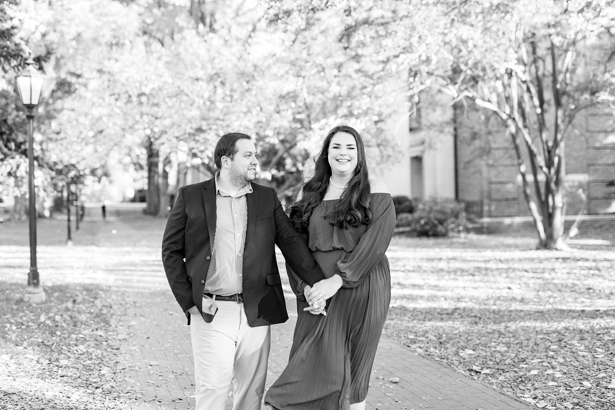 bride and groom hold hands walking through Davidson NC park