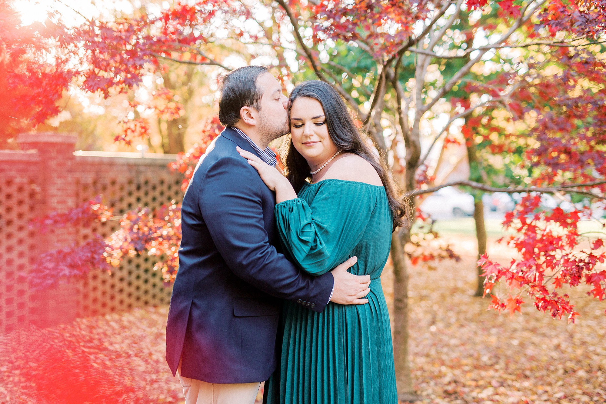groom kisses bride's forehead during Downtown Davidson engagement session
