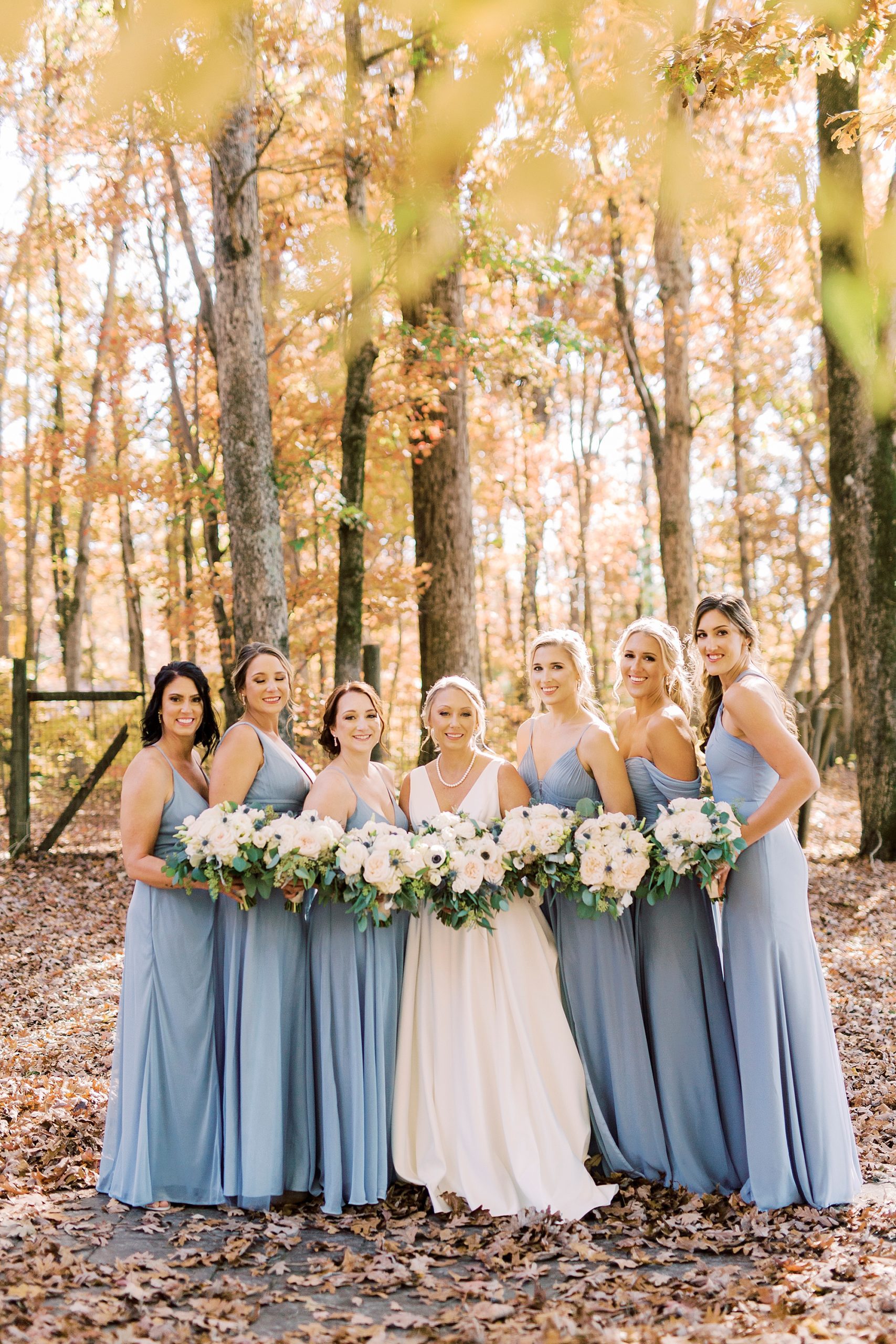 bride and bridesmaids pose in pastel blue gowns