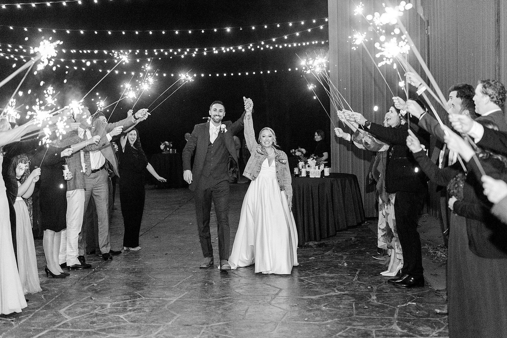 couple cheers during sparkler exit at the Farm at Brusharbor