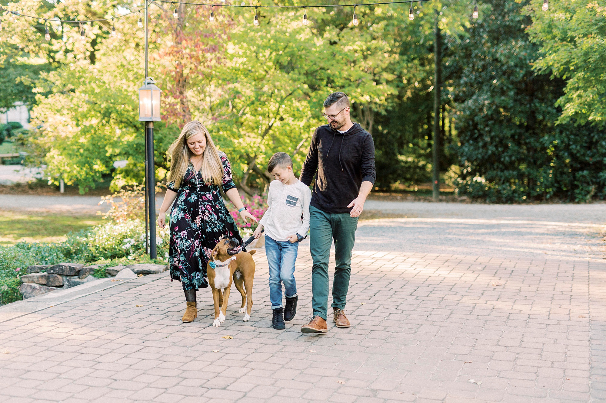 family of three walks with dog during portraits at Ritchie Hill