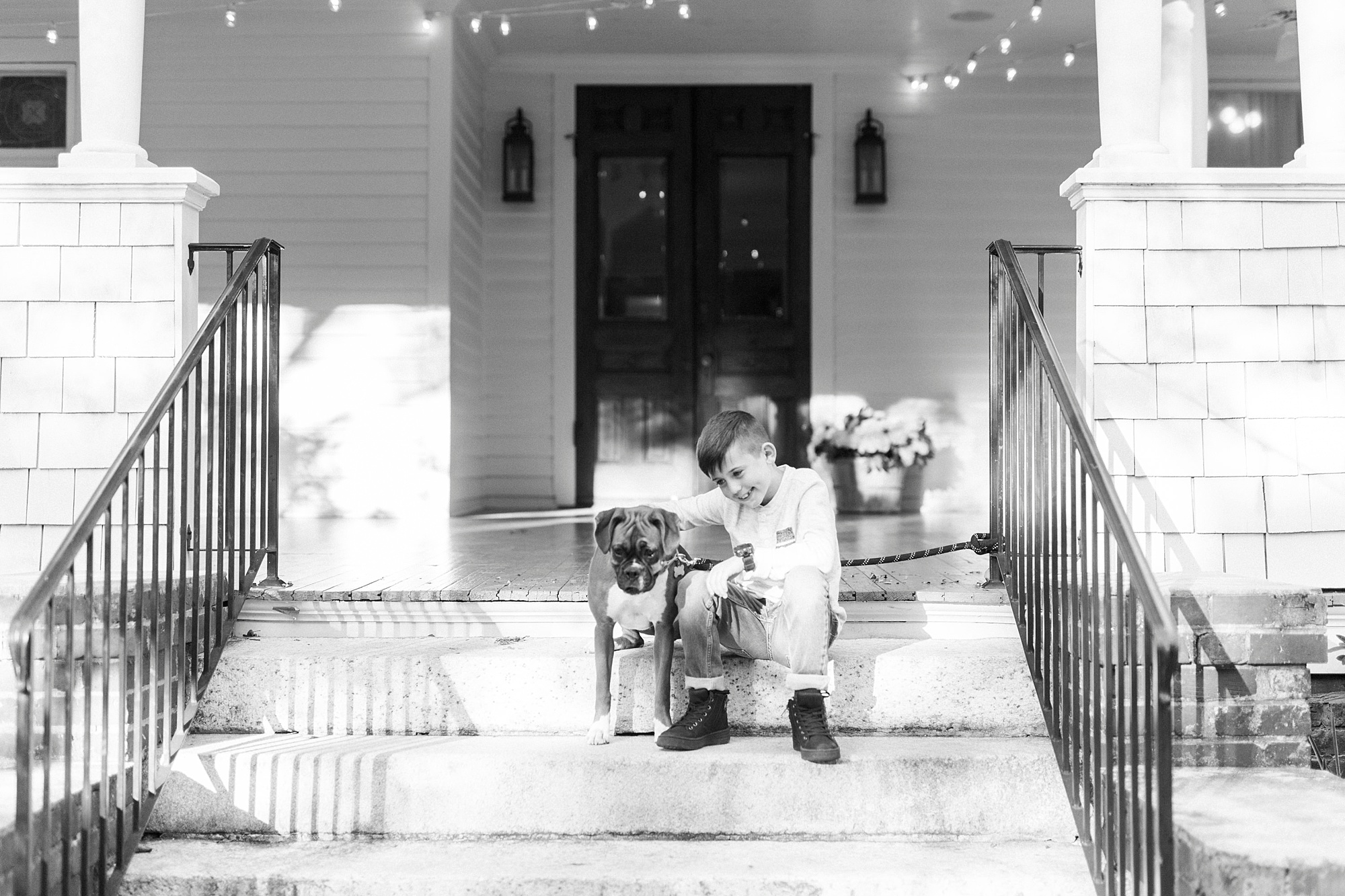 boy sits on steps with dog during Concord NC family photos
