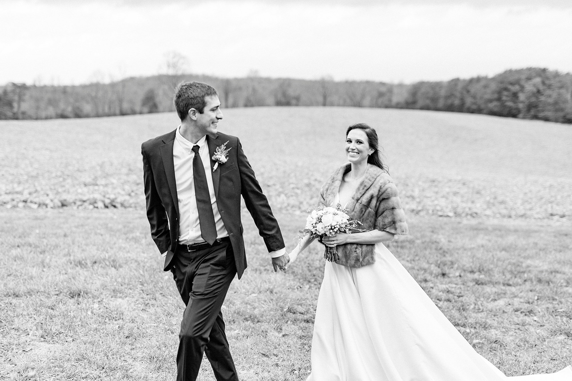 groom looks back at bride during winter wedding portraits