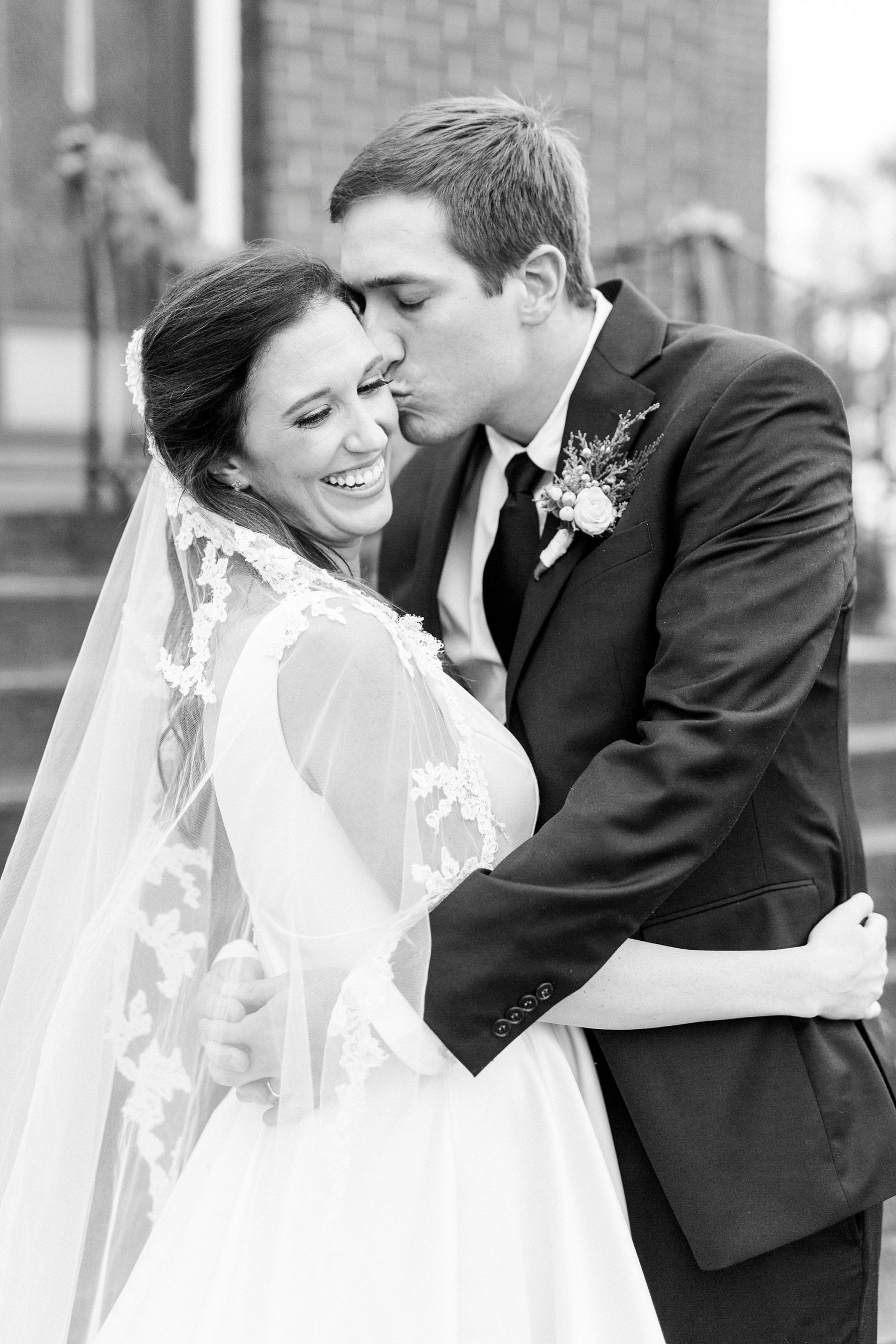 groom kisses bride's cheek outside Bethesda United Methodist Church