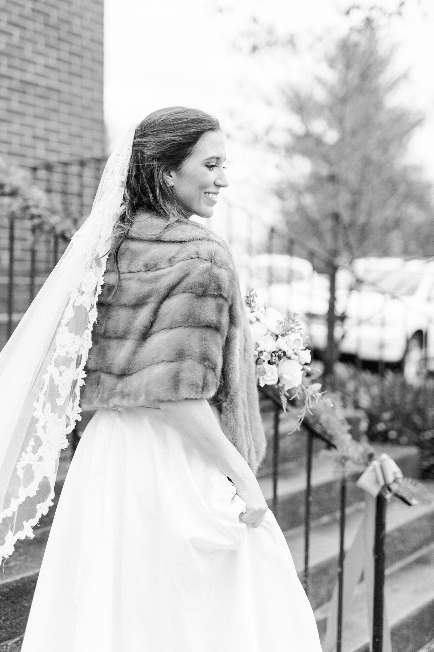 bride looks over shoulder with wrap during portraits on the steps of Bethesda United Methodist Church