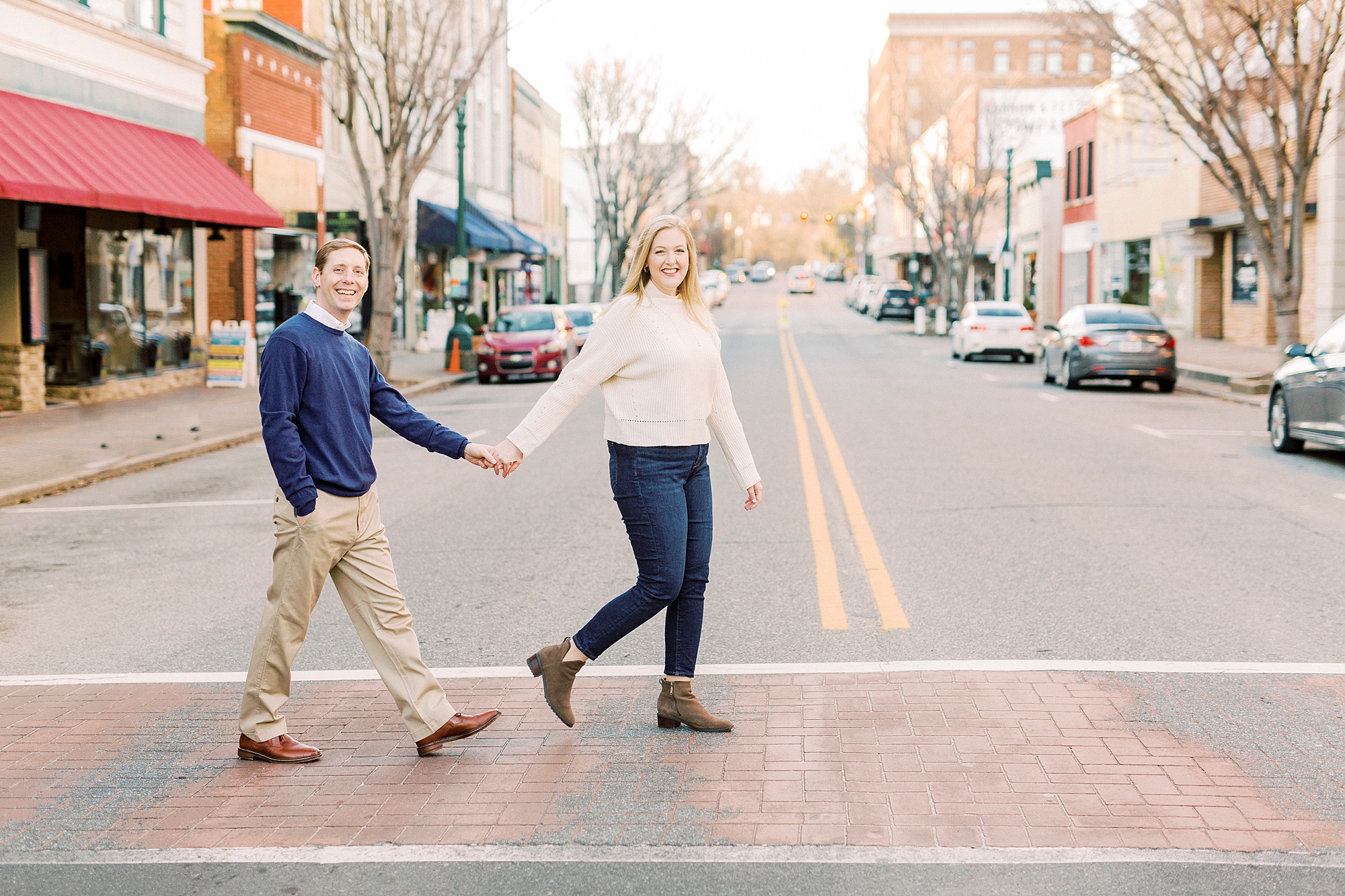 bride and groom hold hands walking through crosswalk in Downtown Concord