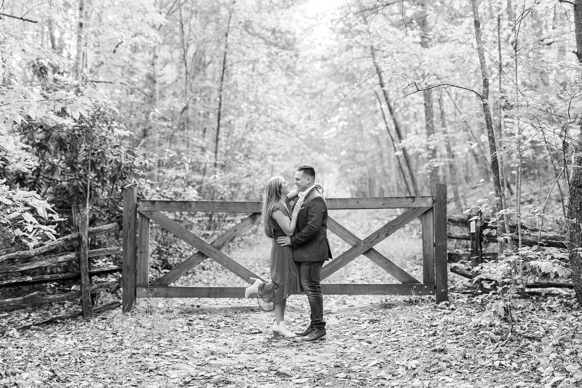 bride and groom hug by gate during engagement session