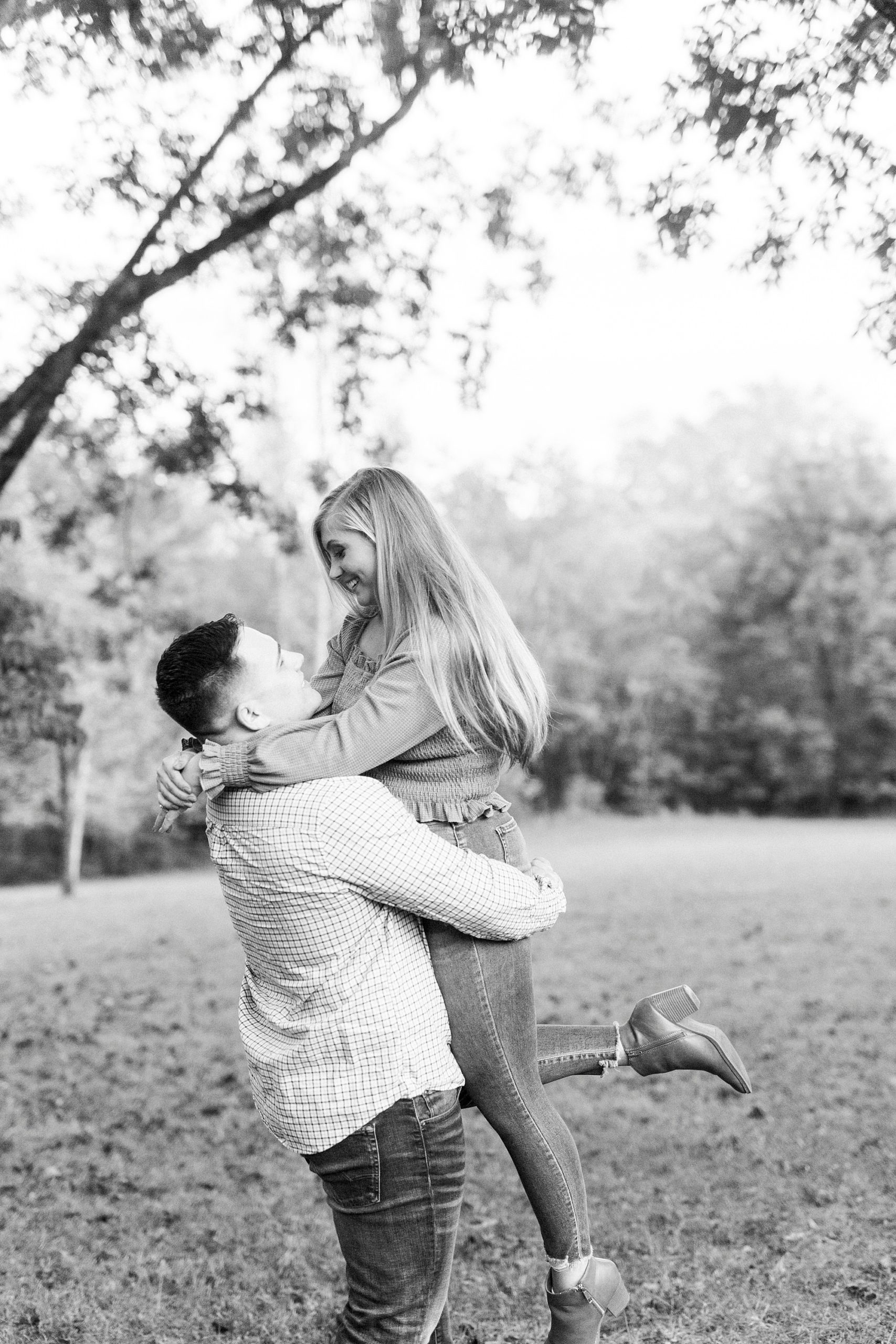 groom lifts bride during fall engagement photos
