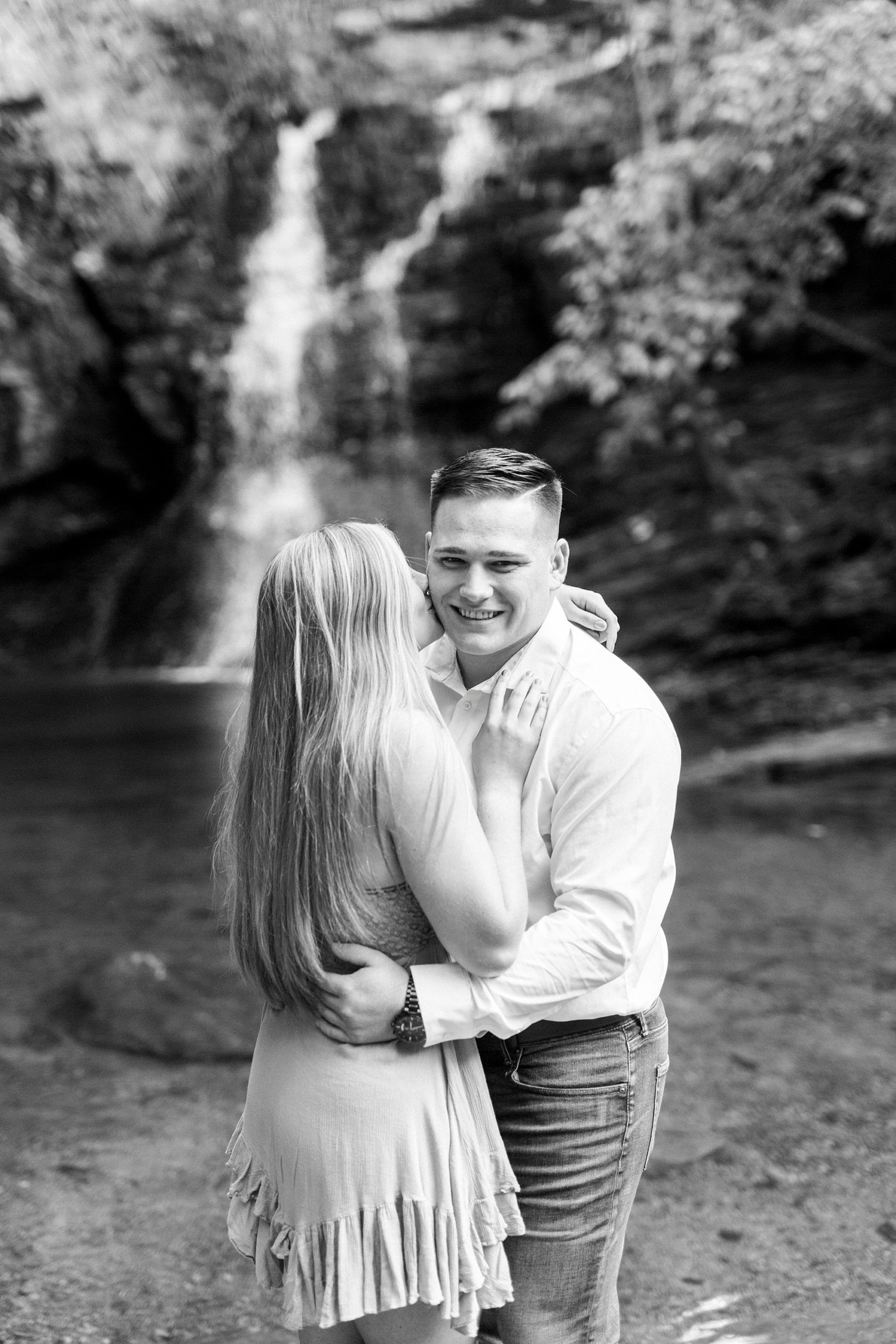 bride and groom hug in waterfall during photos in Lower Cascades