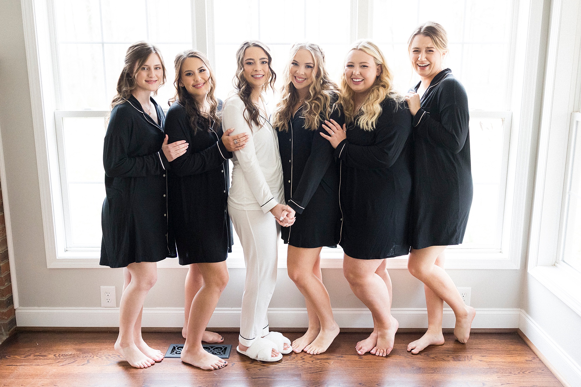 bride poses with bridesmaids in black robes