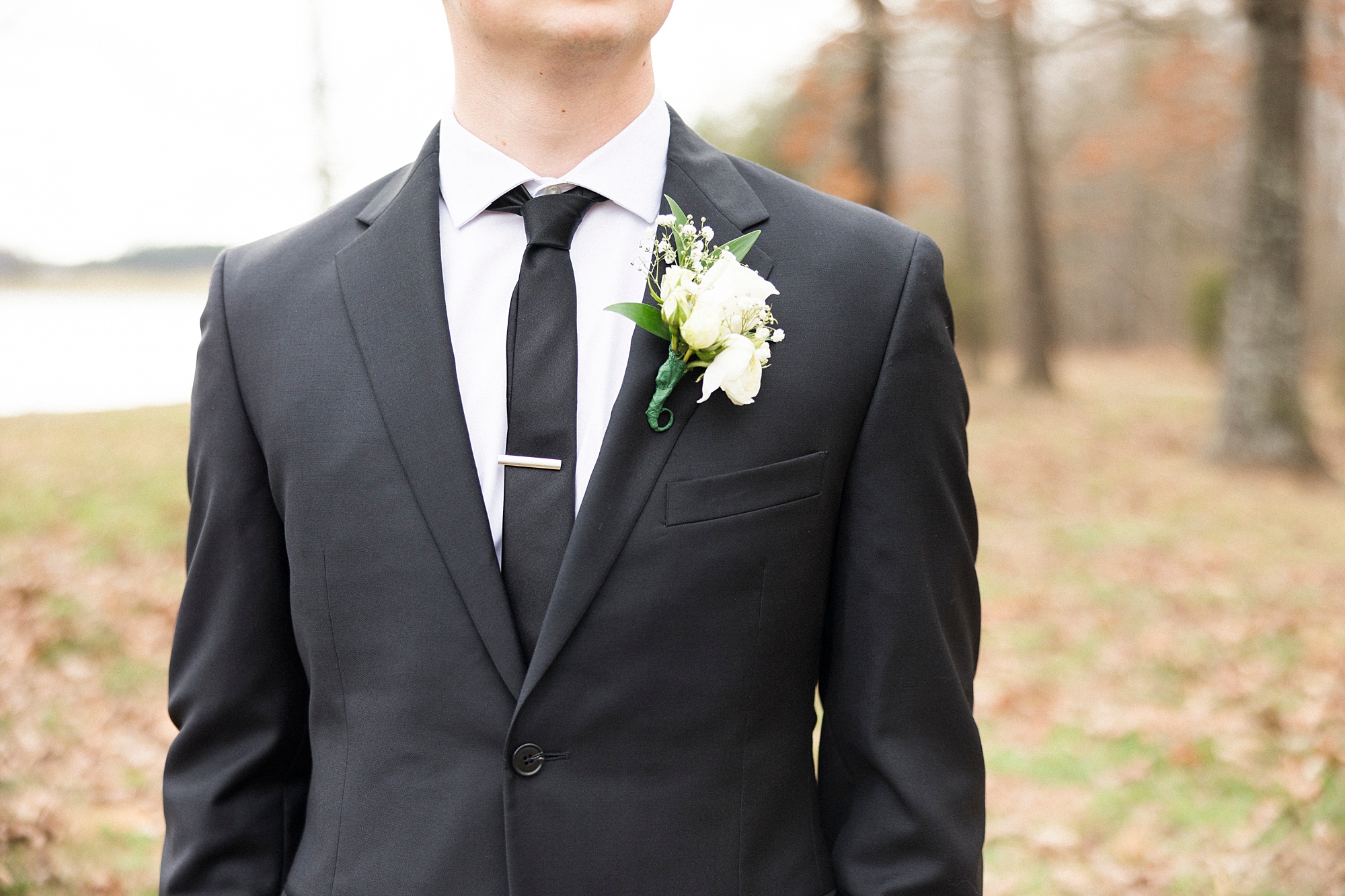 groom's white rose boutonnière for winter wedding day