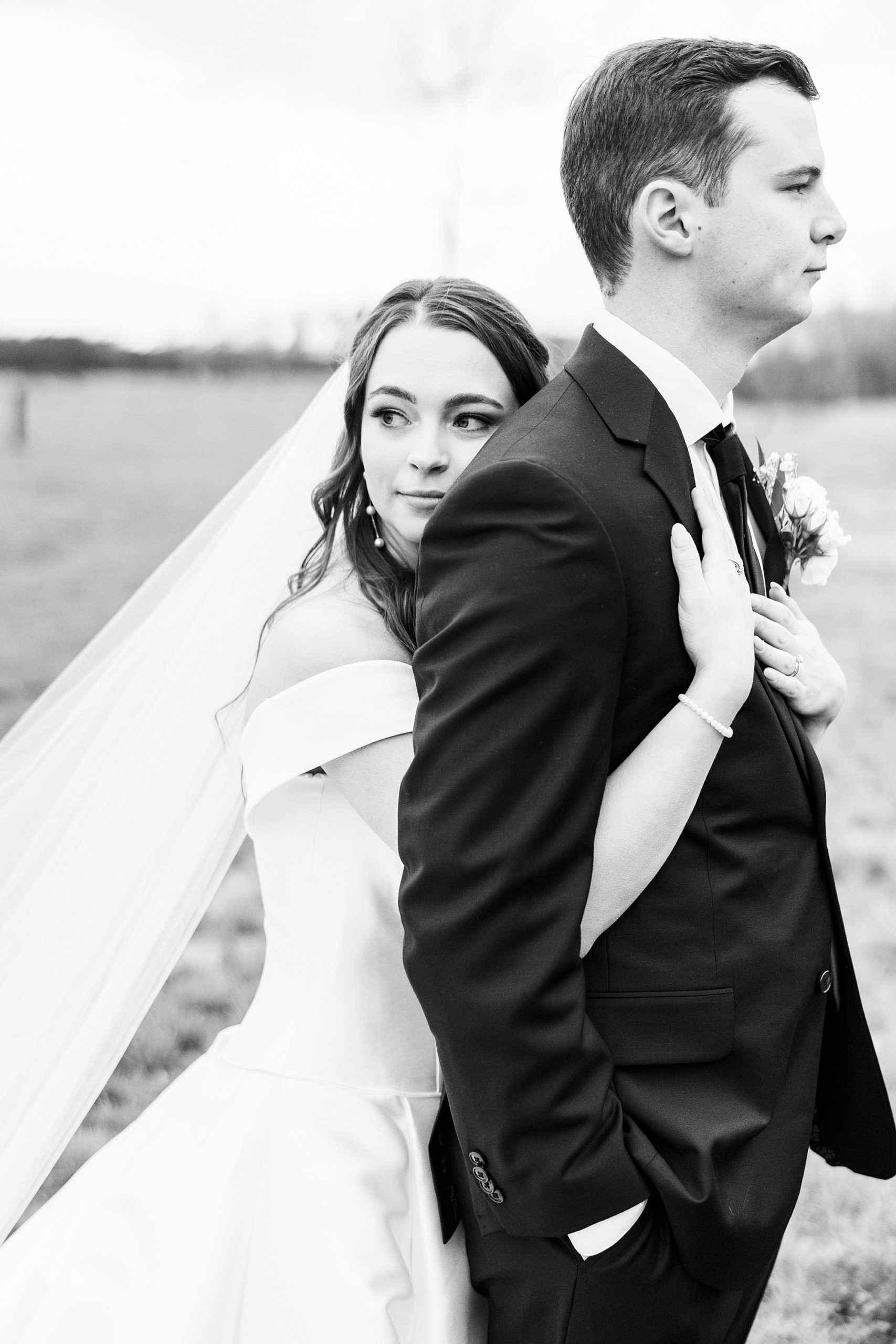 bride leans on groom's back during portraits for winter wedding day