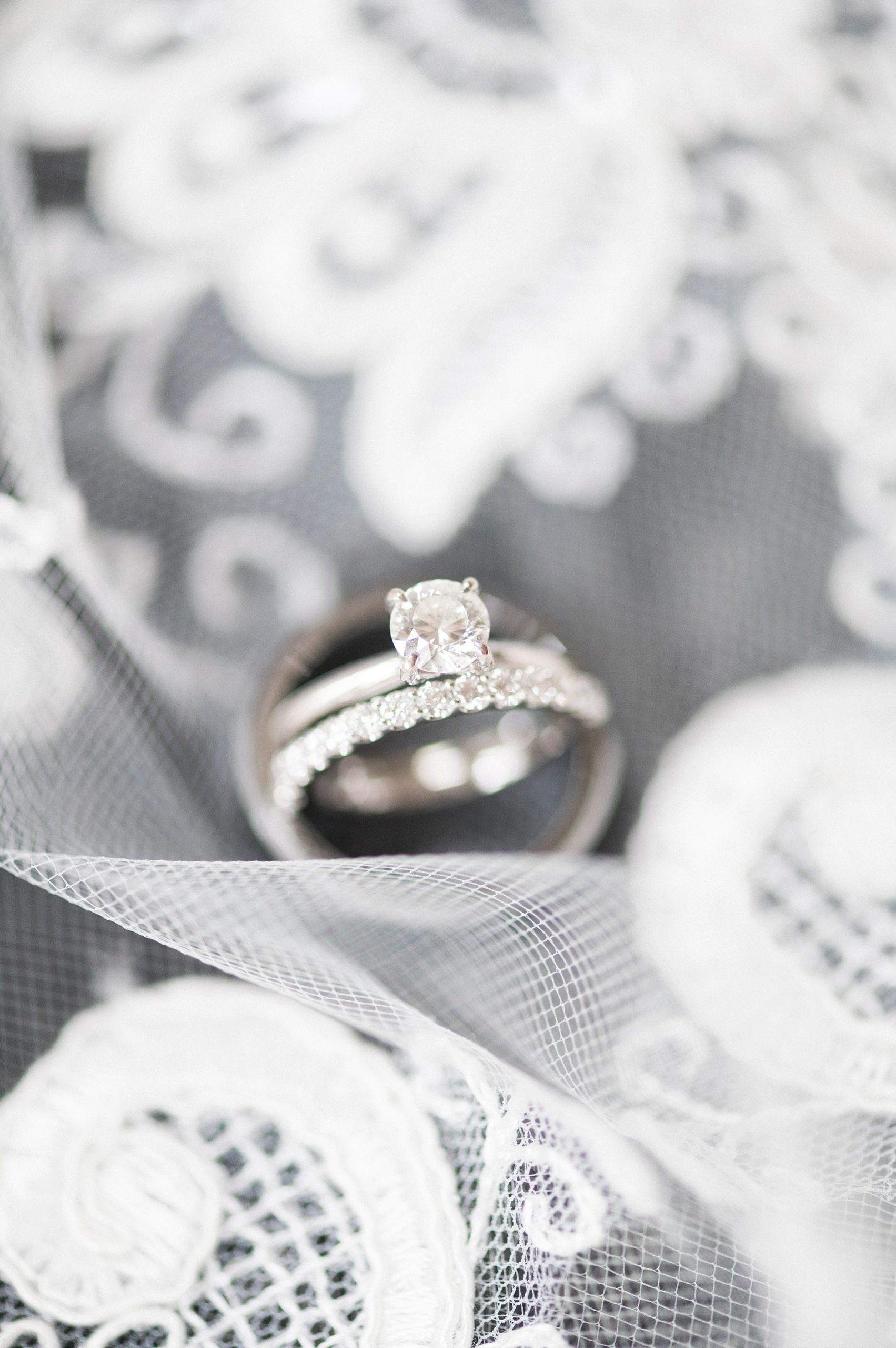 bride's wedding rings lay on veil