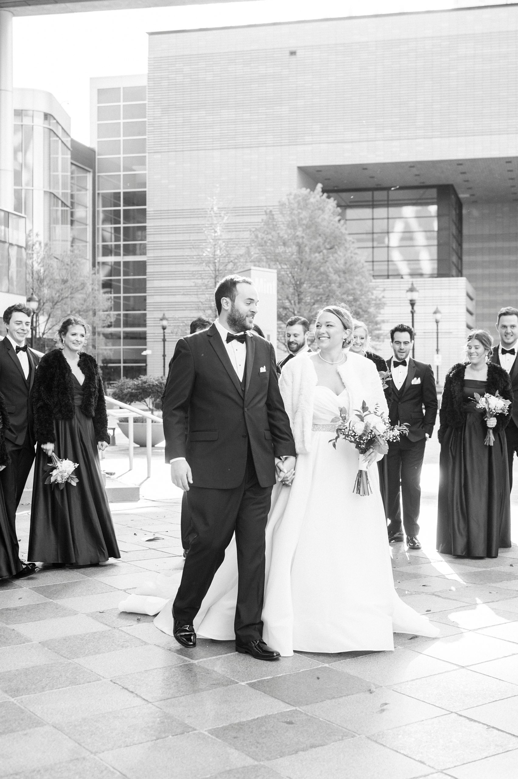 newlyweds walk with bridal party in Charlotte NC