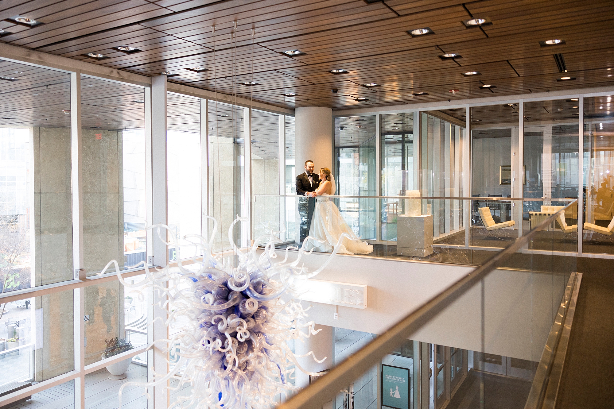 bride and groom stand on balcony in Mint Museum Uptown