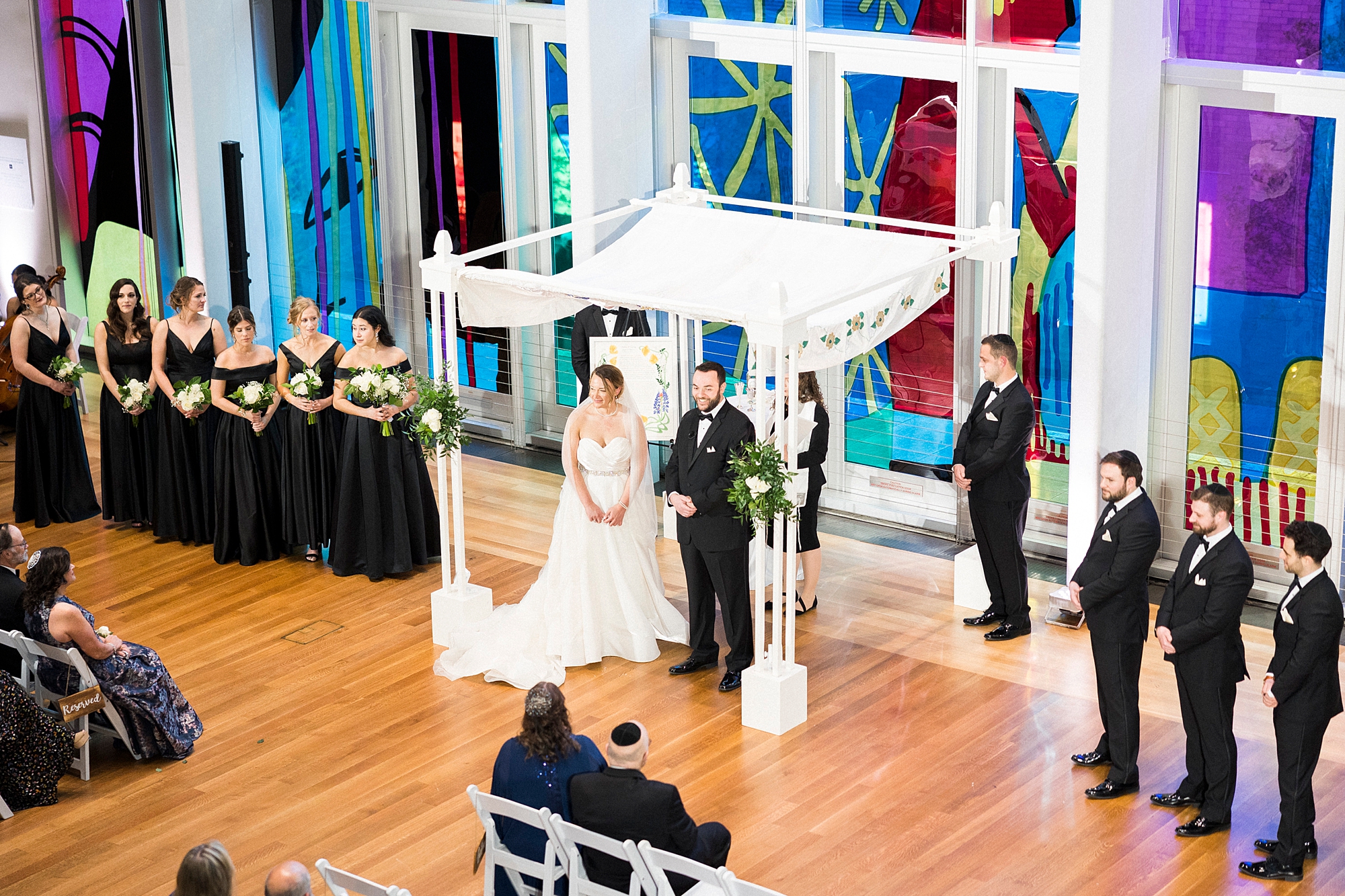 couple stands under the canopy during Jewish wedding ceremony at Temple Beth El