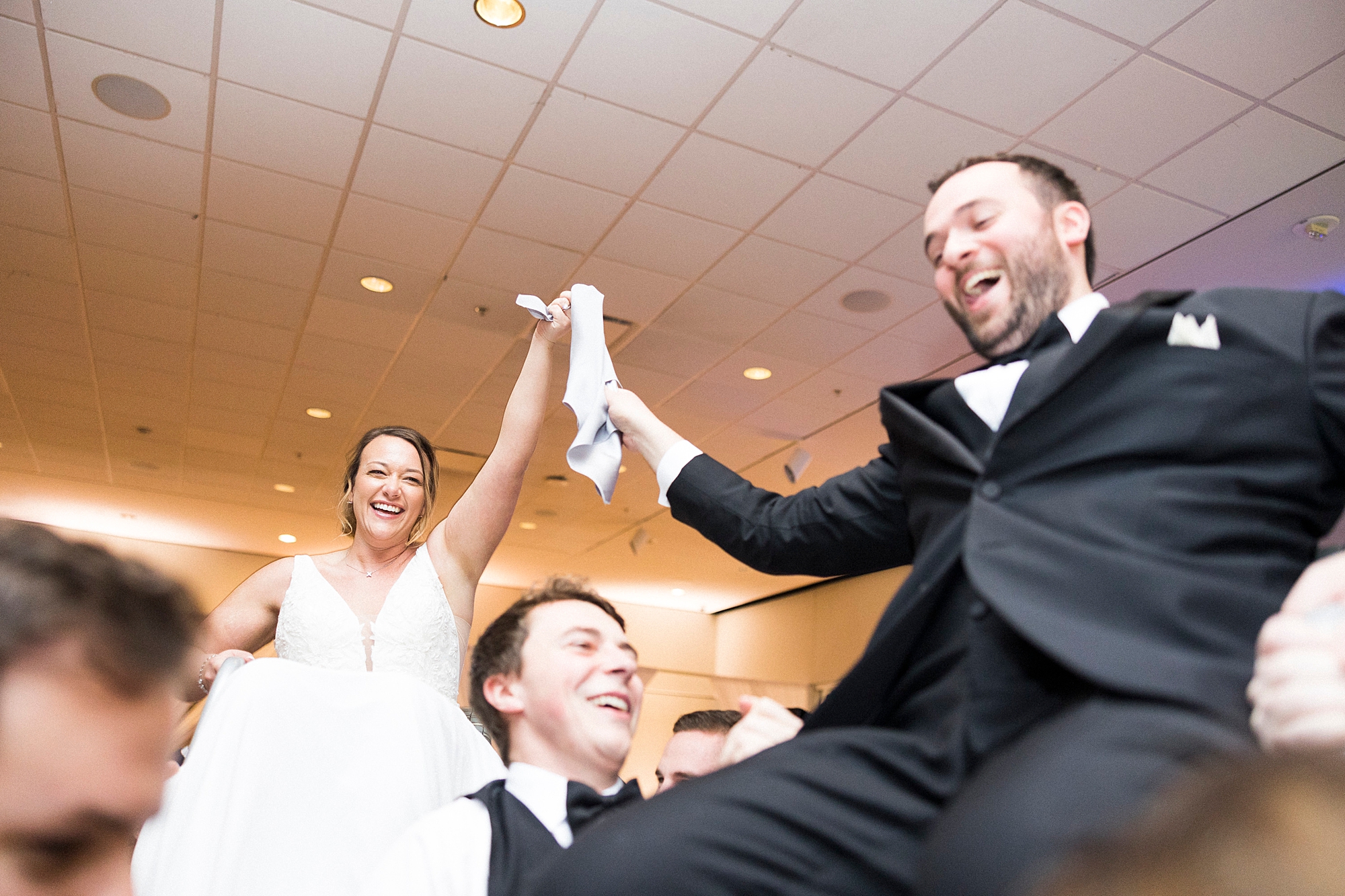 newlyweds hold handkerchief during Hora