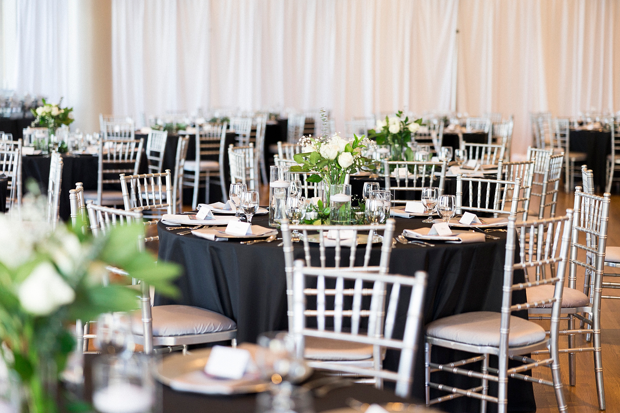 wedding reception with ivory flowers and black table cloths