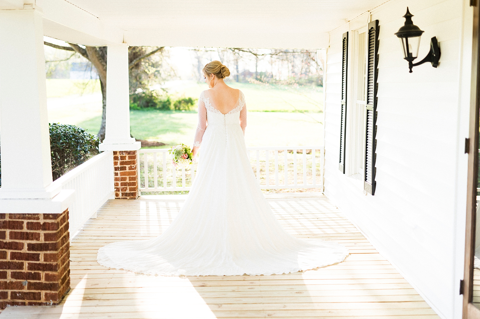 bride poses on patio of Mooresville bridal portraits