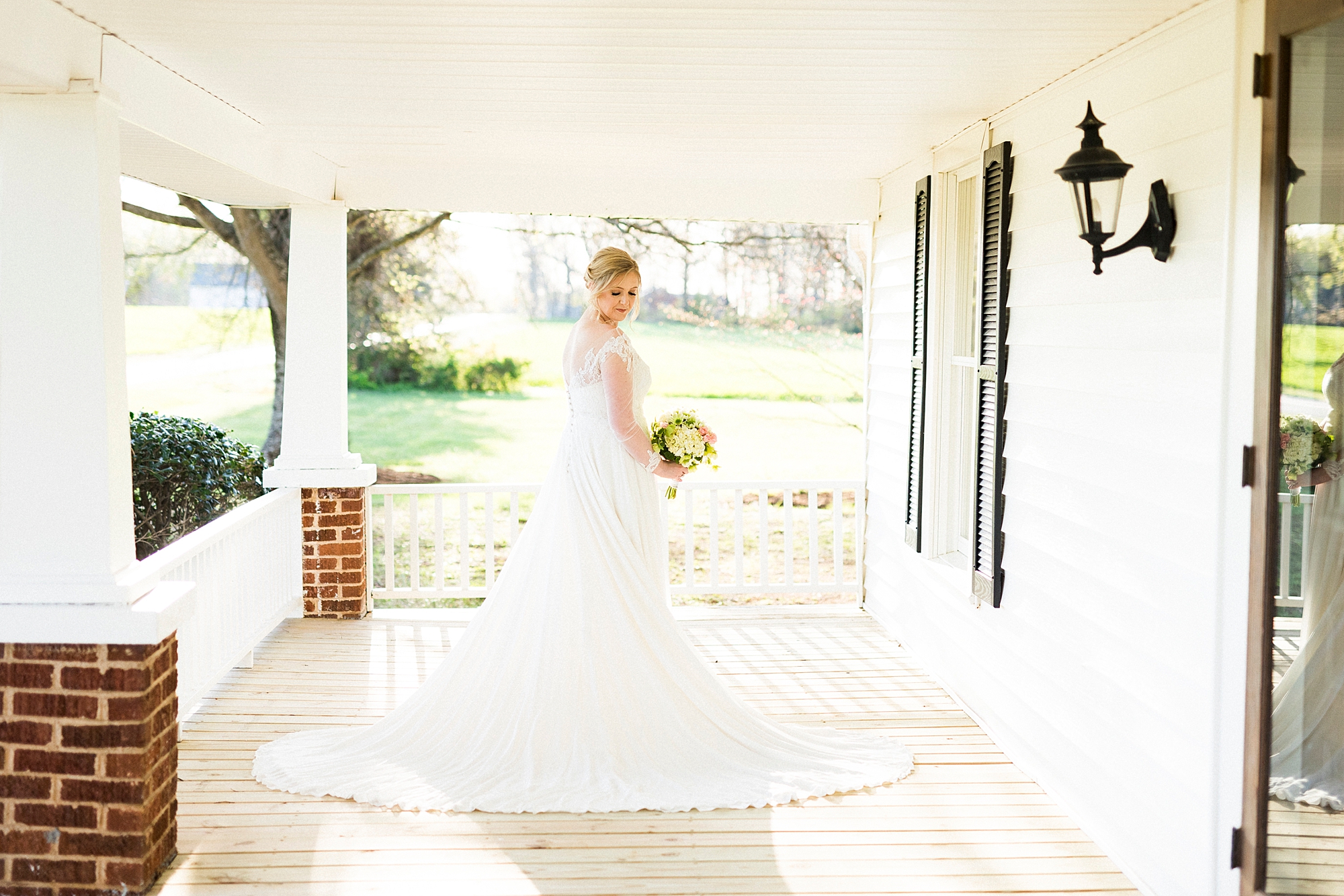 bride stands on patio with dress splayed behind her