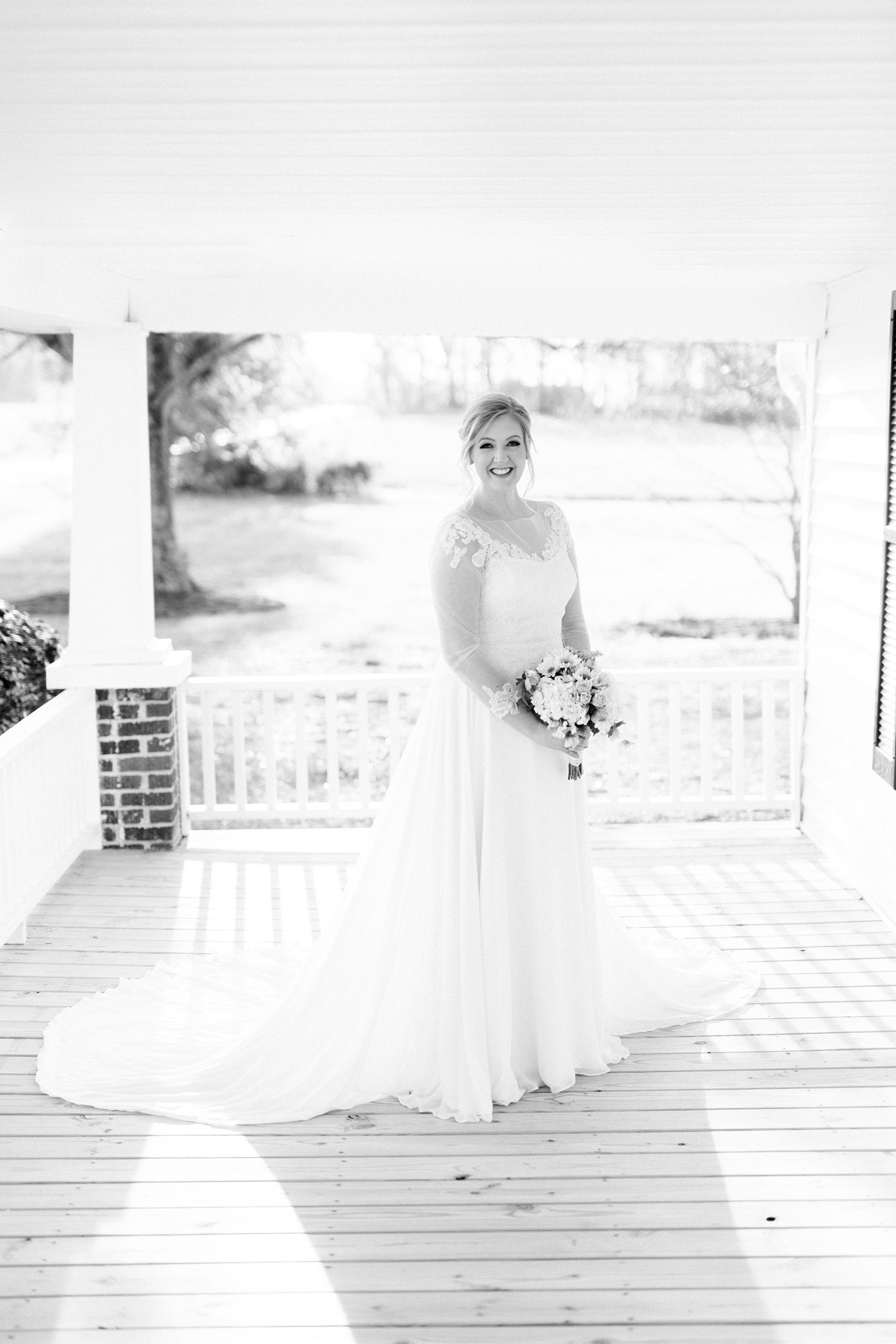 bride stands on front porch during Mooresville bridal portraits
