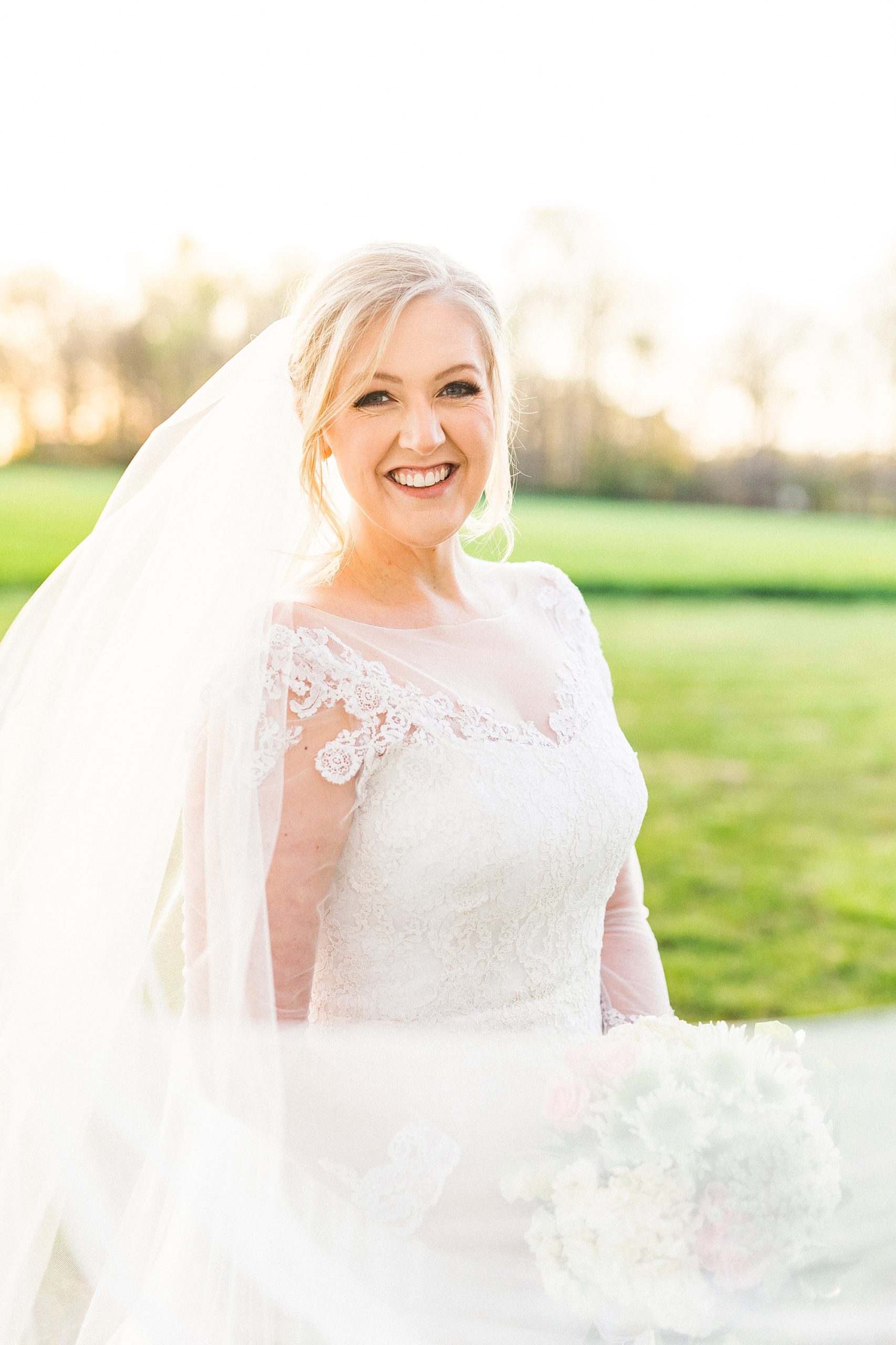 bride smiles with veil draped around her during Mooresville bridal portraits