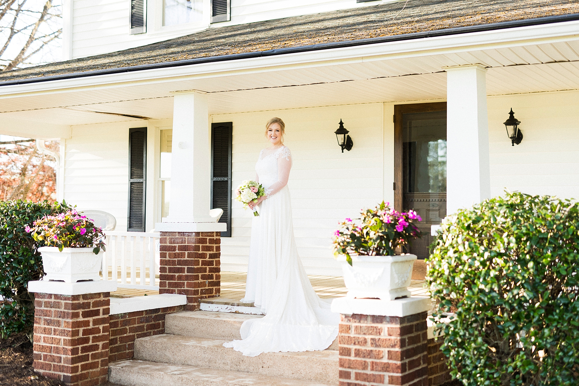 bride poses on farmhouse steps in Moorseville NC