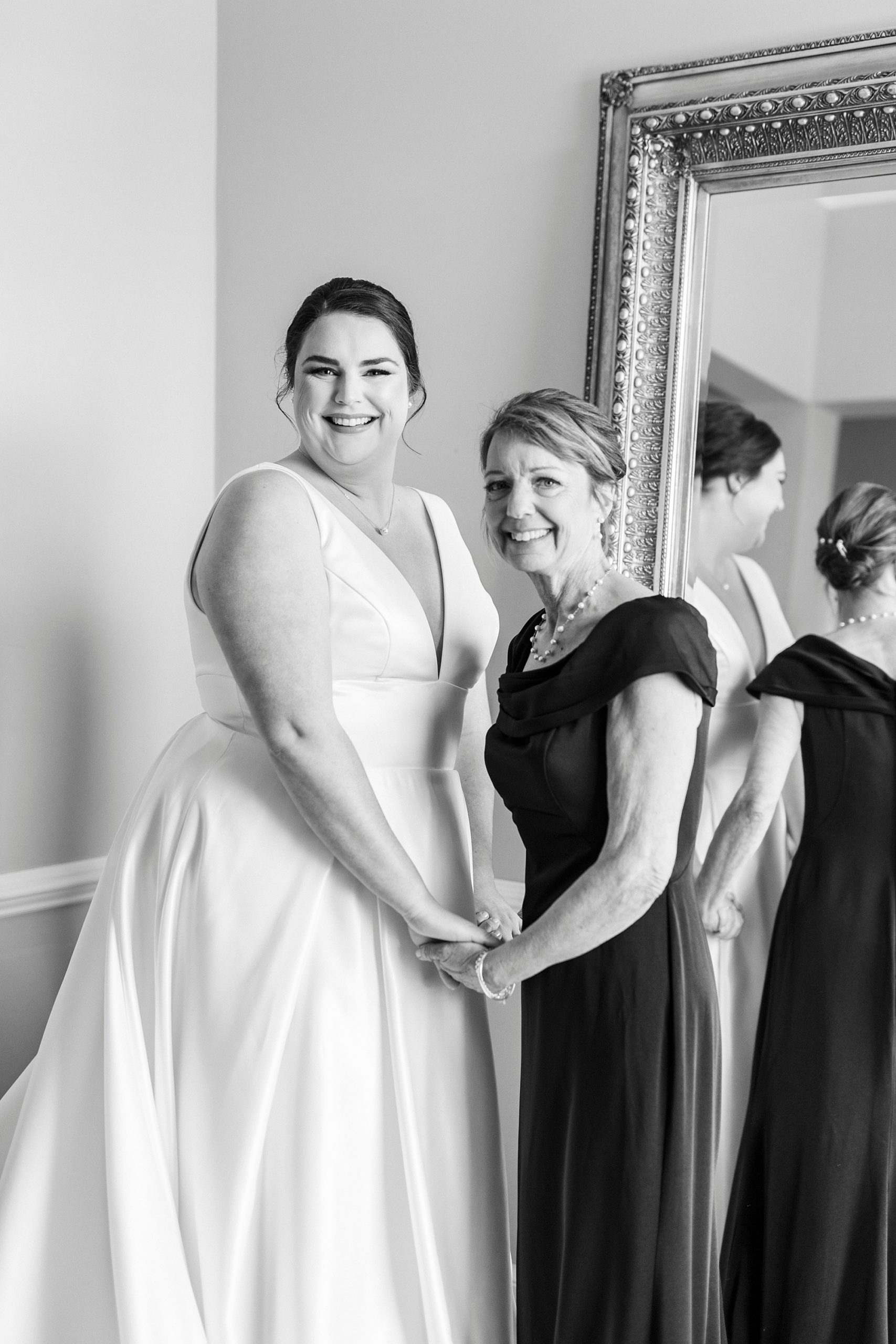 bride and mom hold hands after preparing for NC wedding day