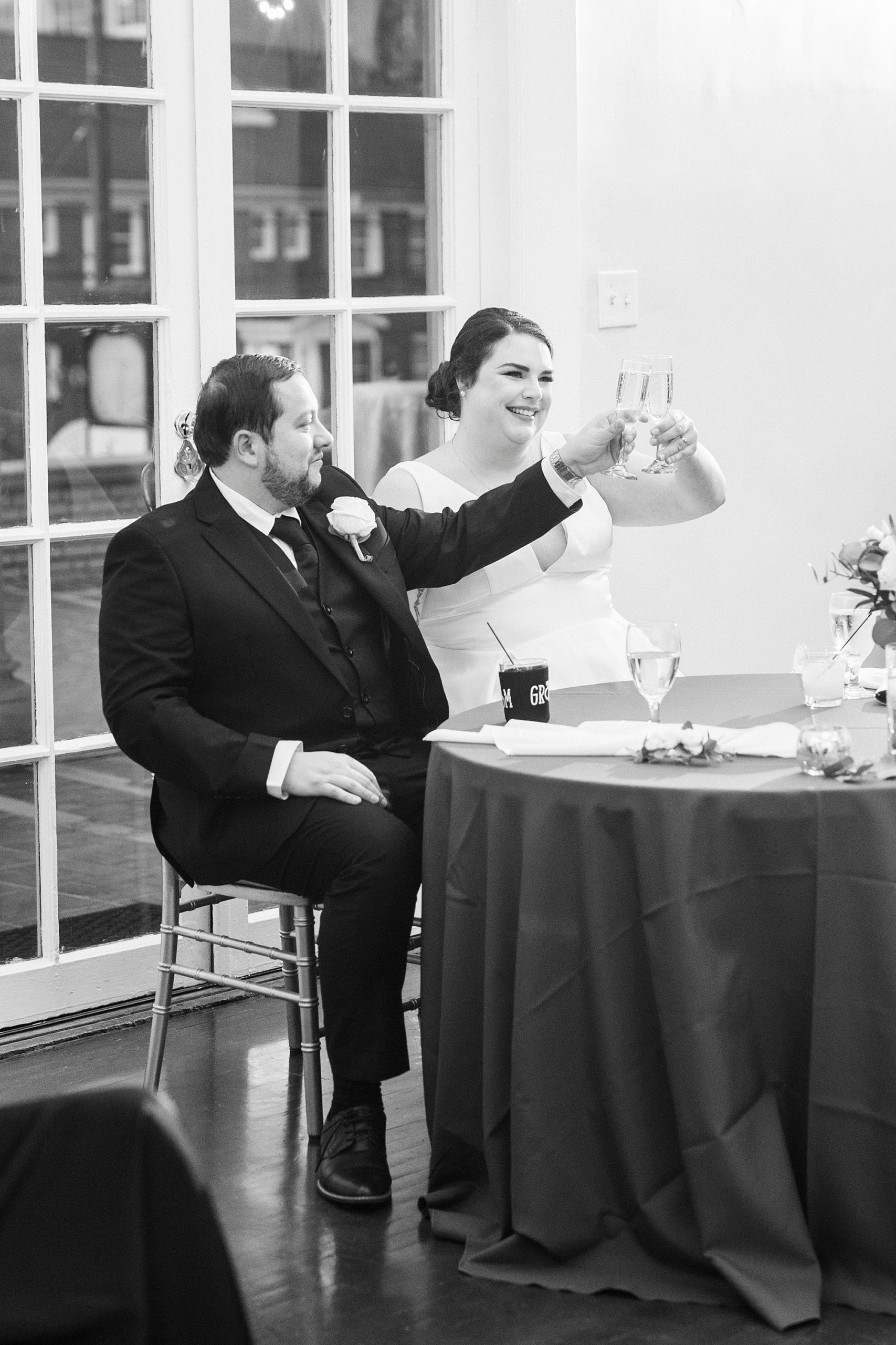 couple lifts glasses during toasts at Gastonia NC wedding reception