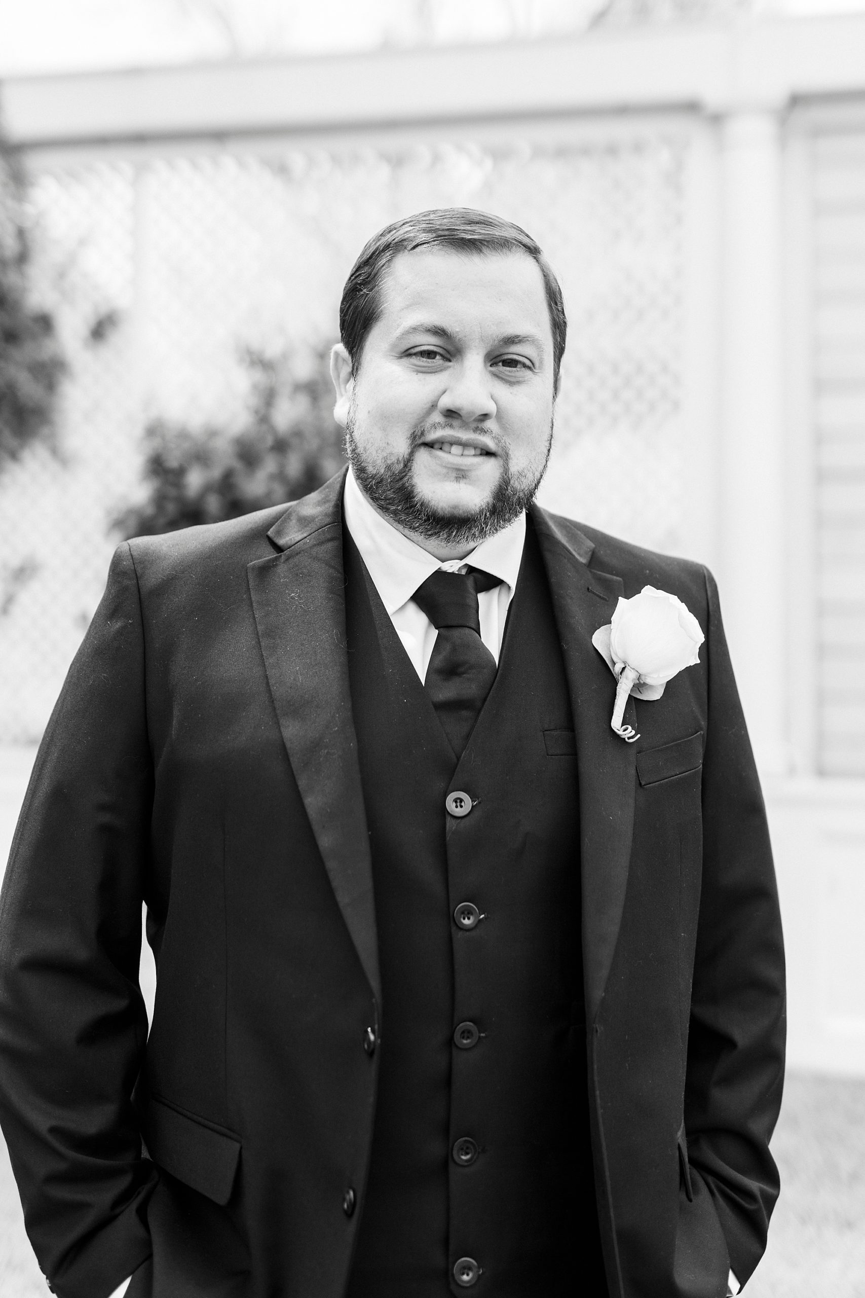 groom stands with hands in pockets in custom suit