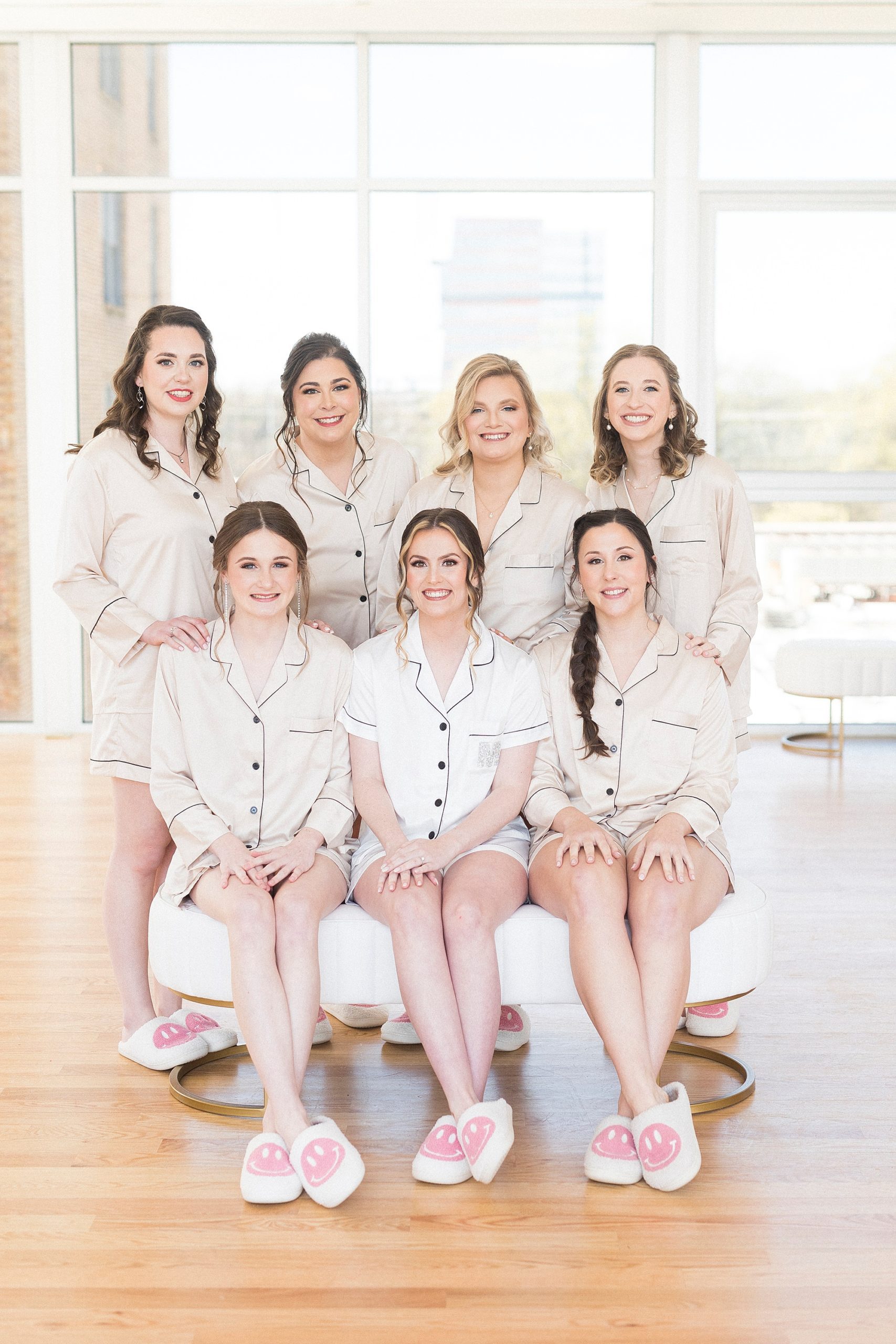 bride sits with bridesmaids in matching white pajamas