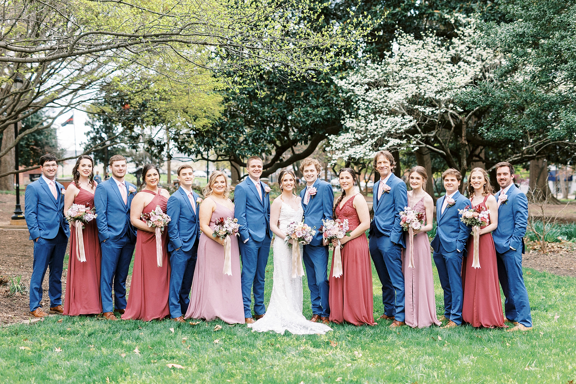 bride and groom stand with wedding party
