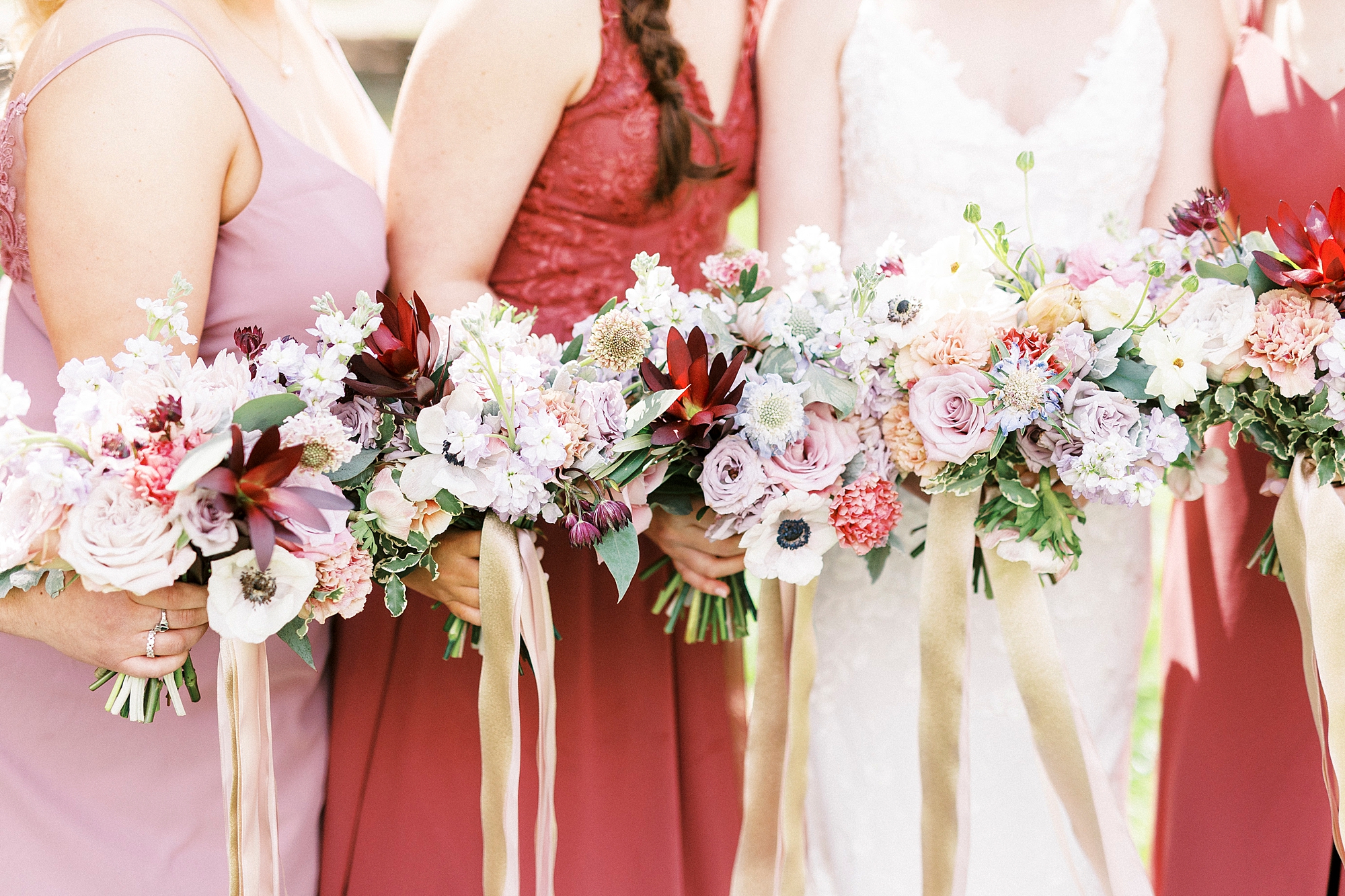 bride and bridesmaids hold pastel bouquets
