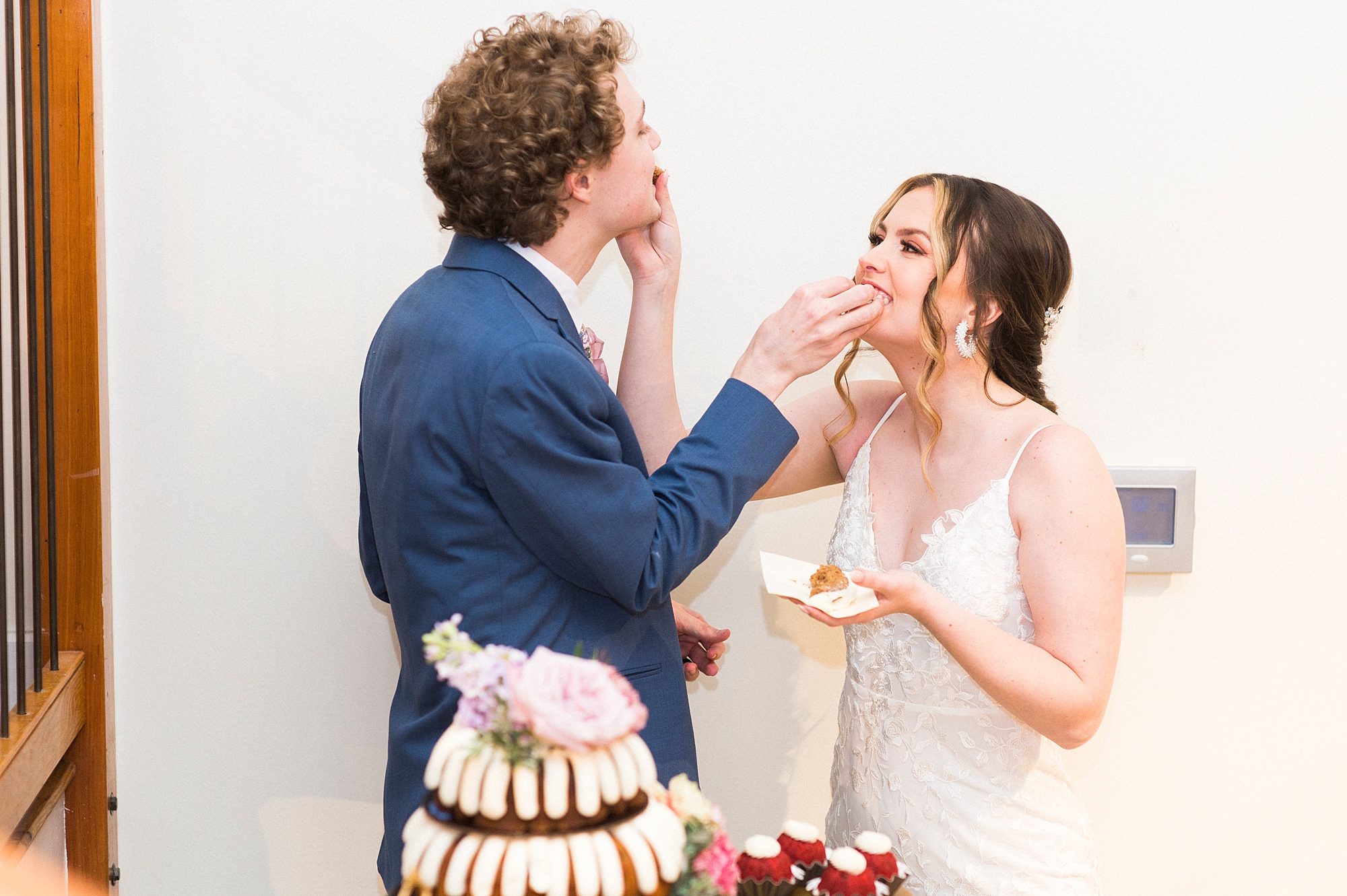 newlyweds feed each other cake during Raleigh NC wedding reception