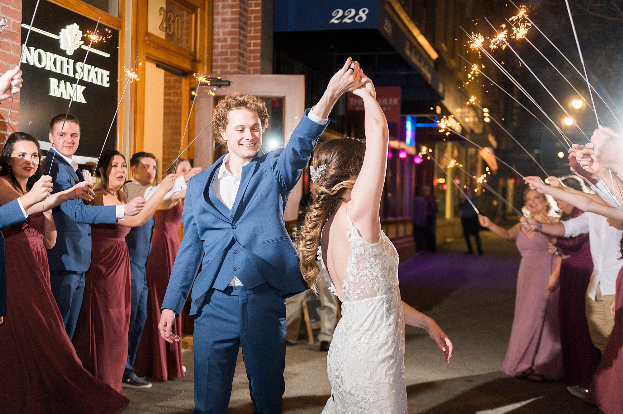 groom twirls bride during sparkler exit
