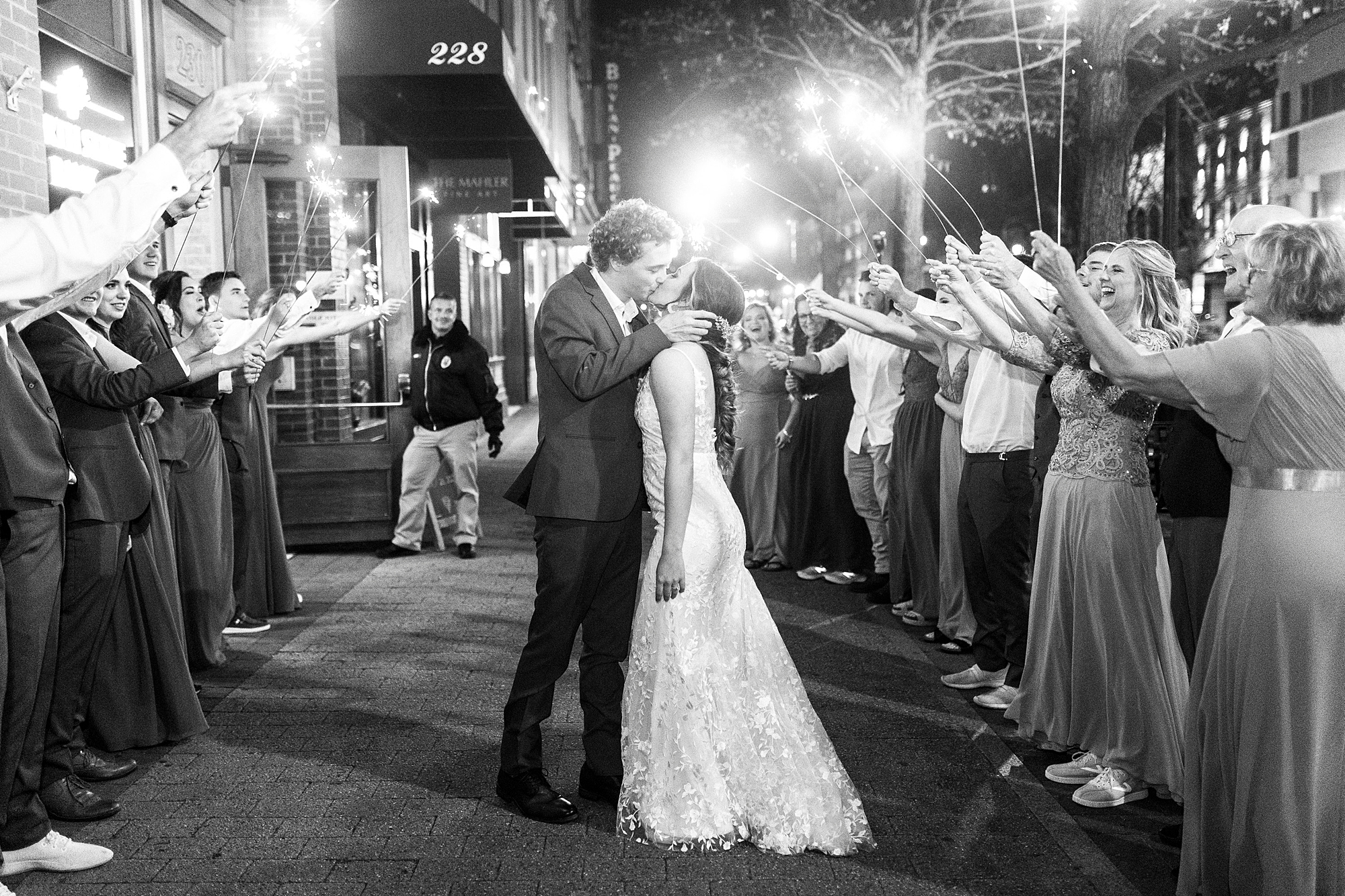 newlyweds kiss during sparkler exit outside the Stockroom at 230