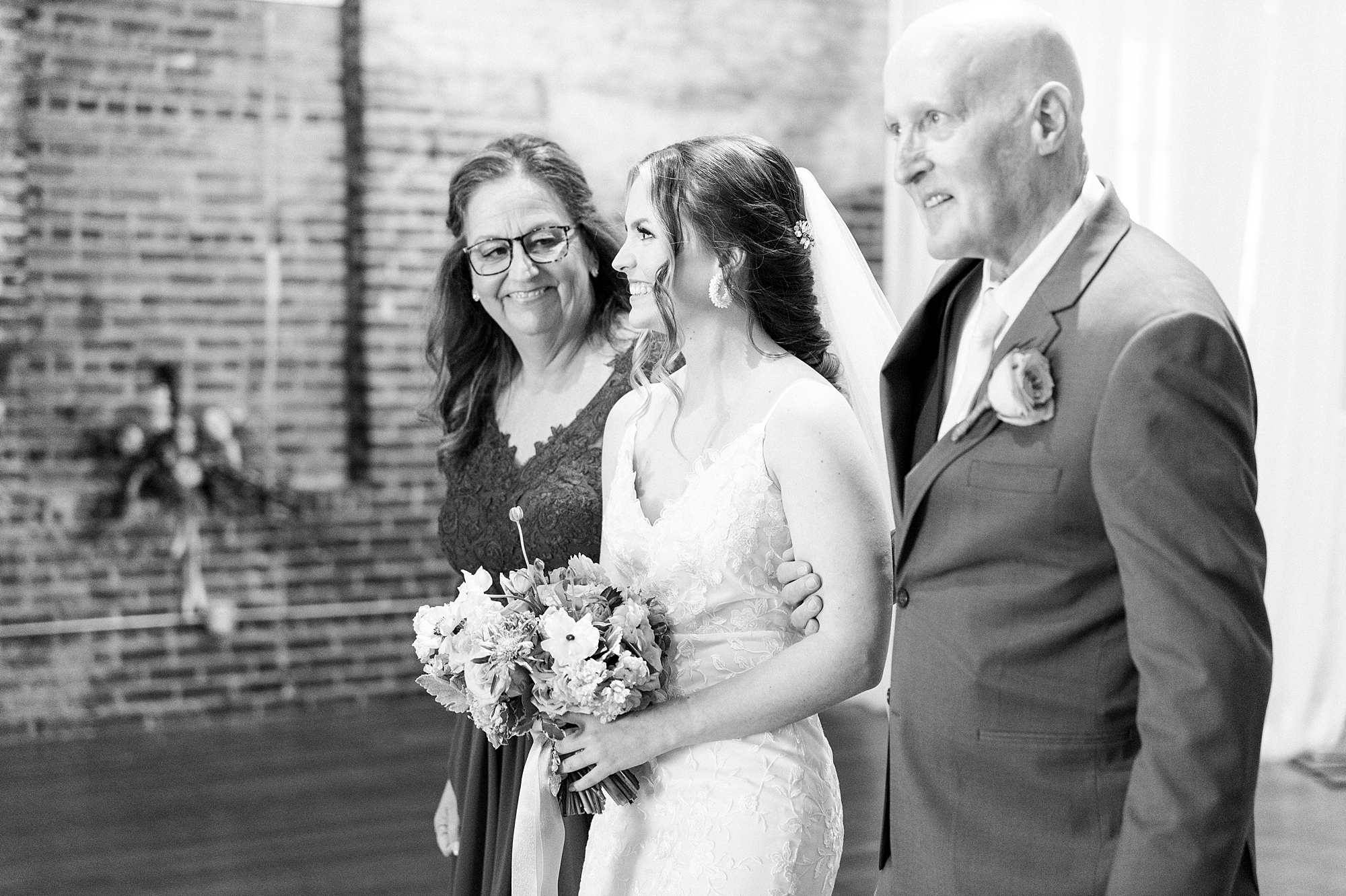 bride walks down aisle with parents in Raleigh NC