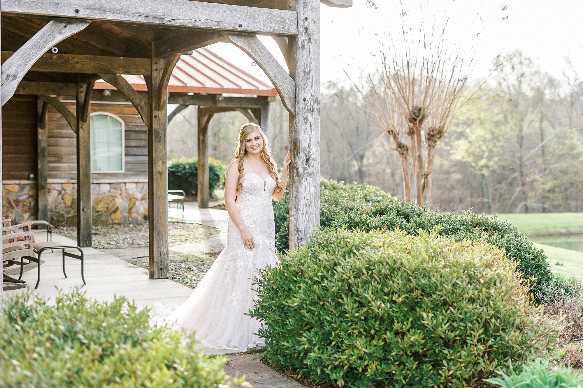 bride walks under wooden arch at The Stable at Riverview