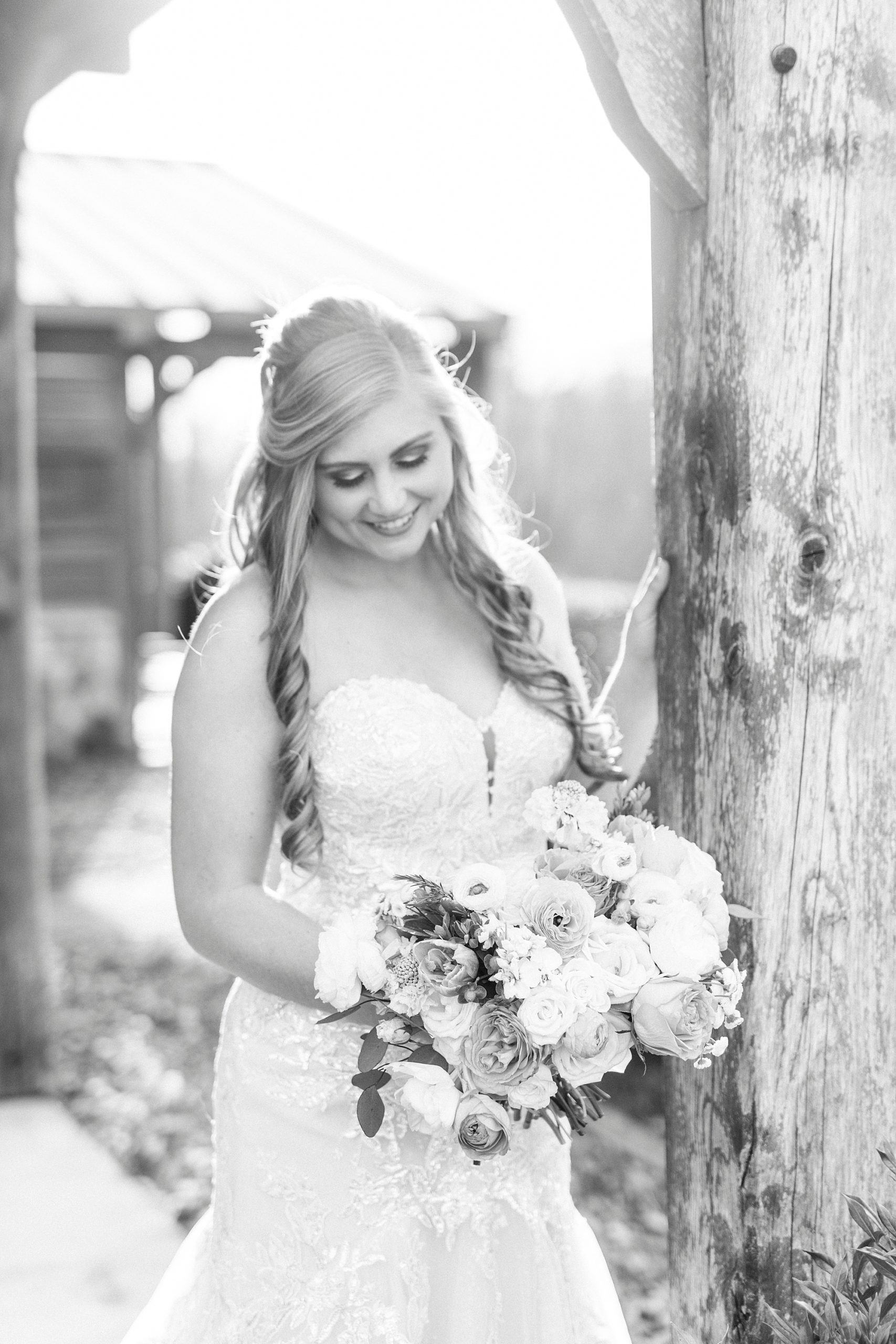 bride smiles down at bouquet during bridal portraits