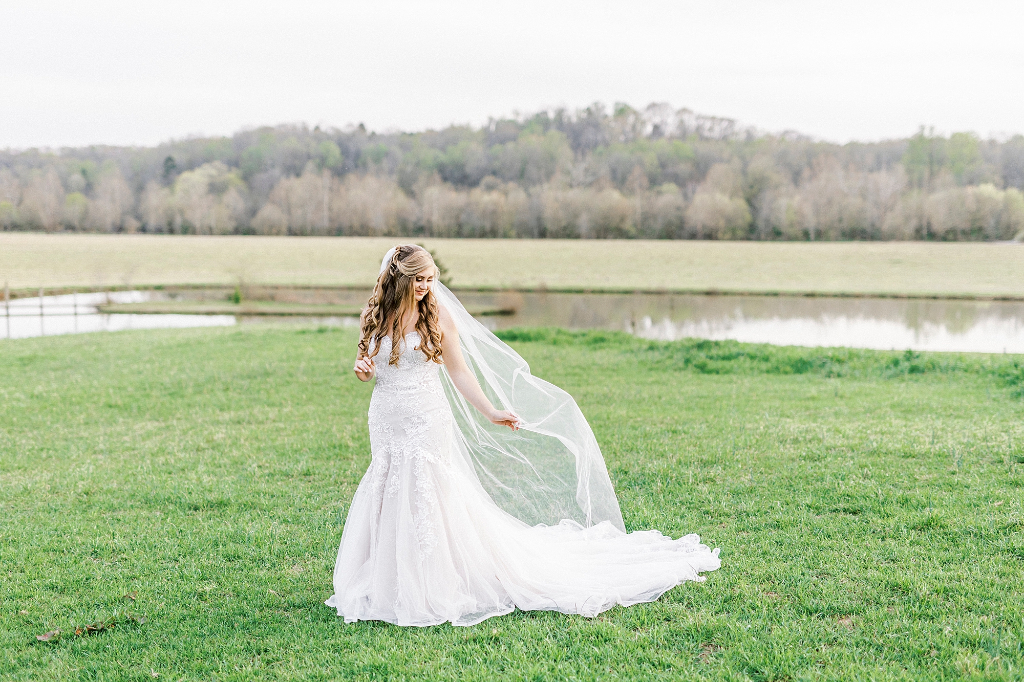 bride holds veil out behind her during NC bridal session