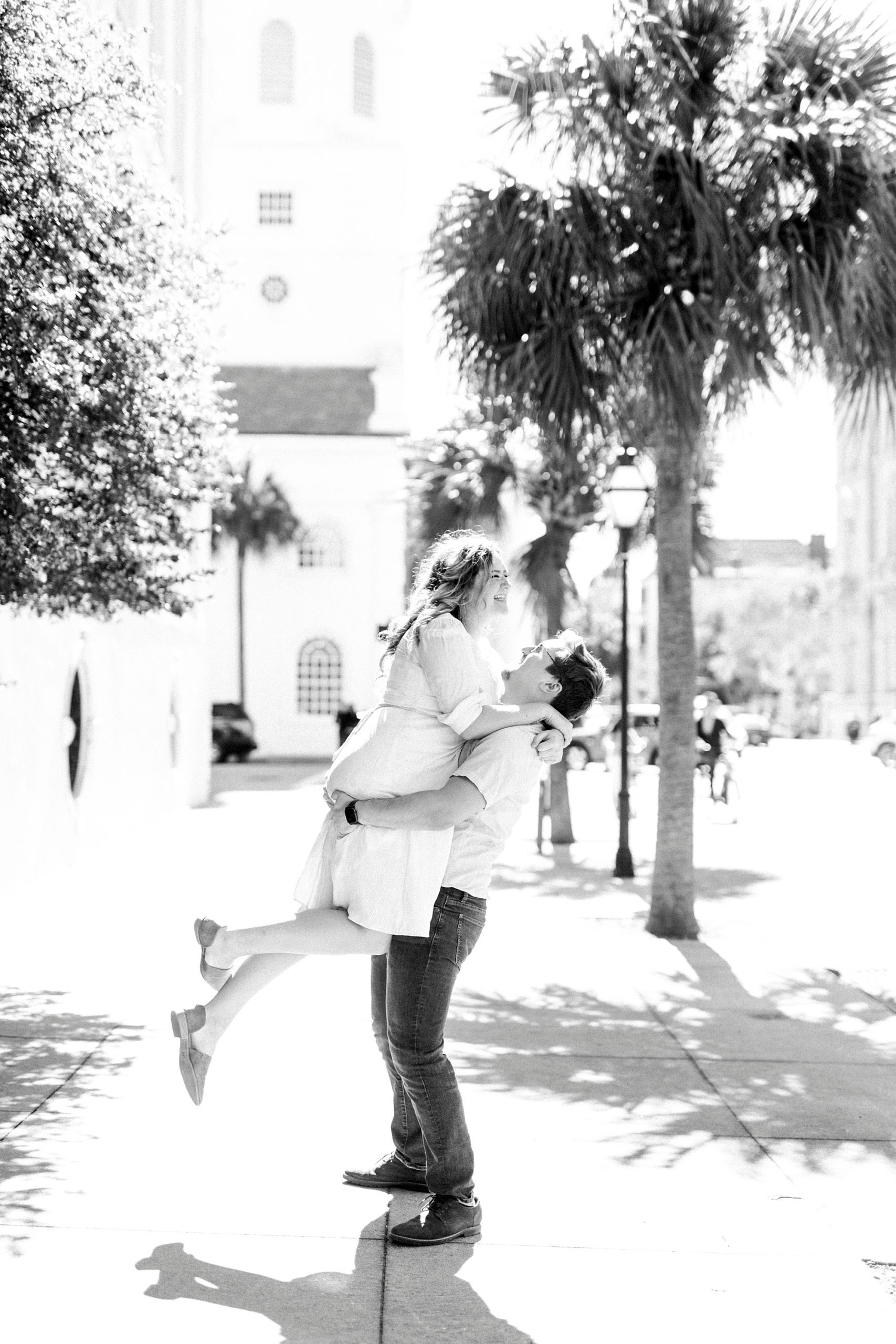 husband lifts wife up during downtown Charleston anniversary portraits 